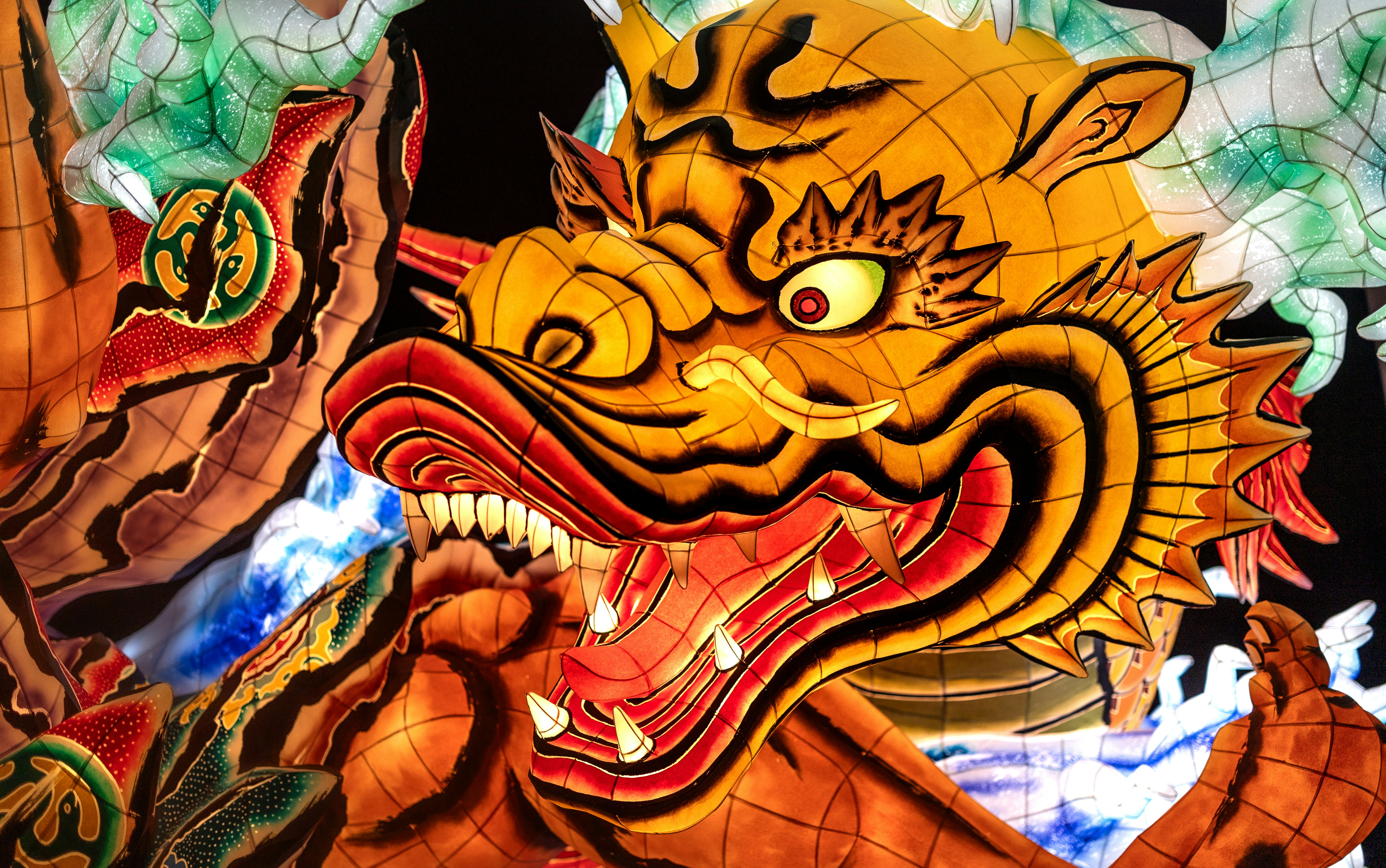 Vibrant, illuminated dragon-like festival float with intricate details.