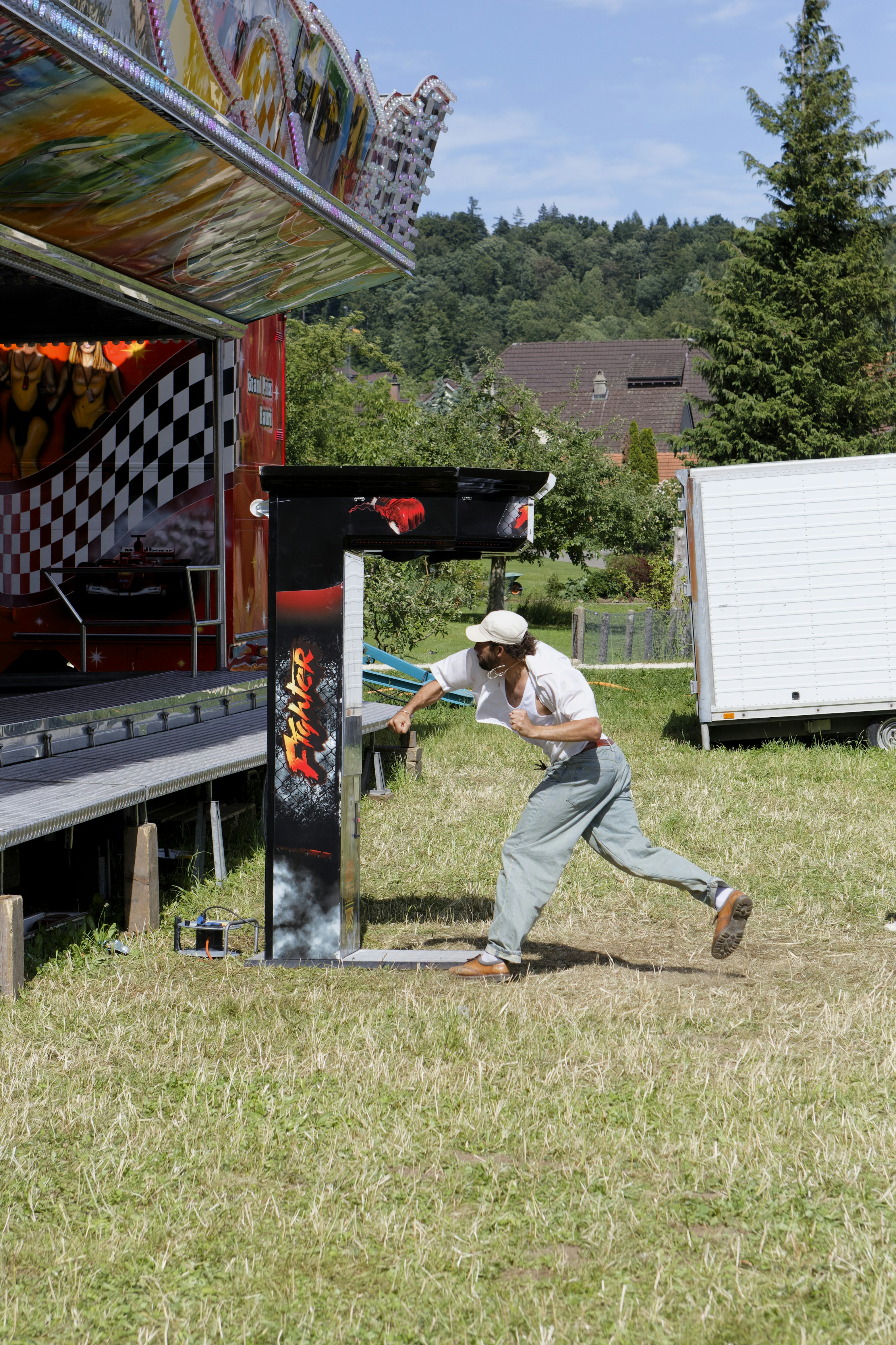A person punches a carnival game machine outdoors.