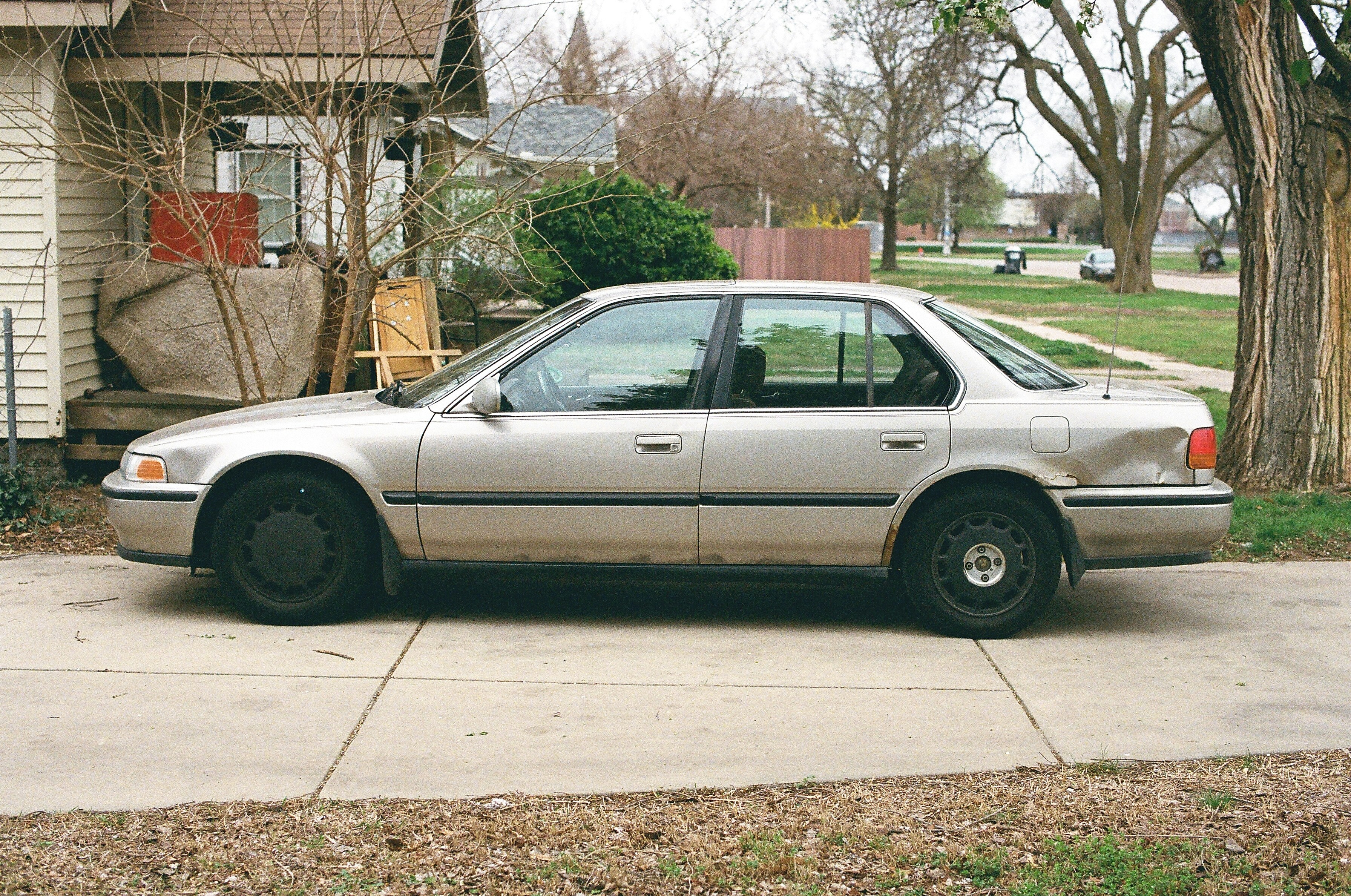 A silver sedan car parked on a concrete driveway.