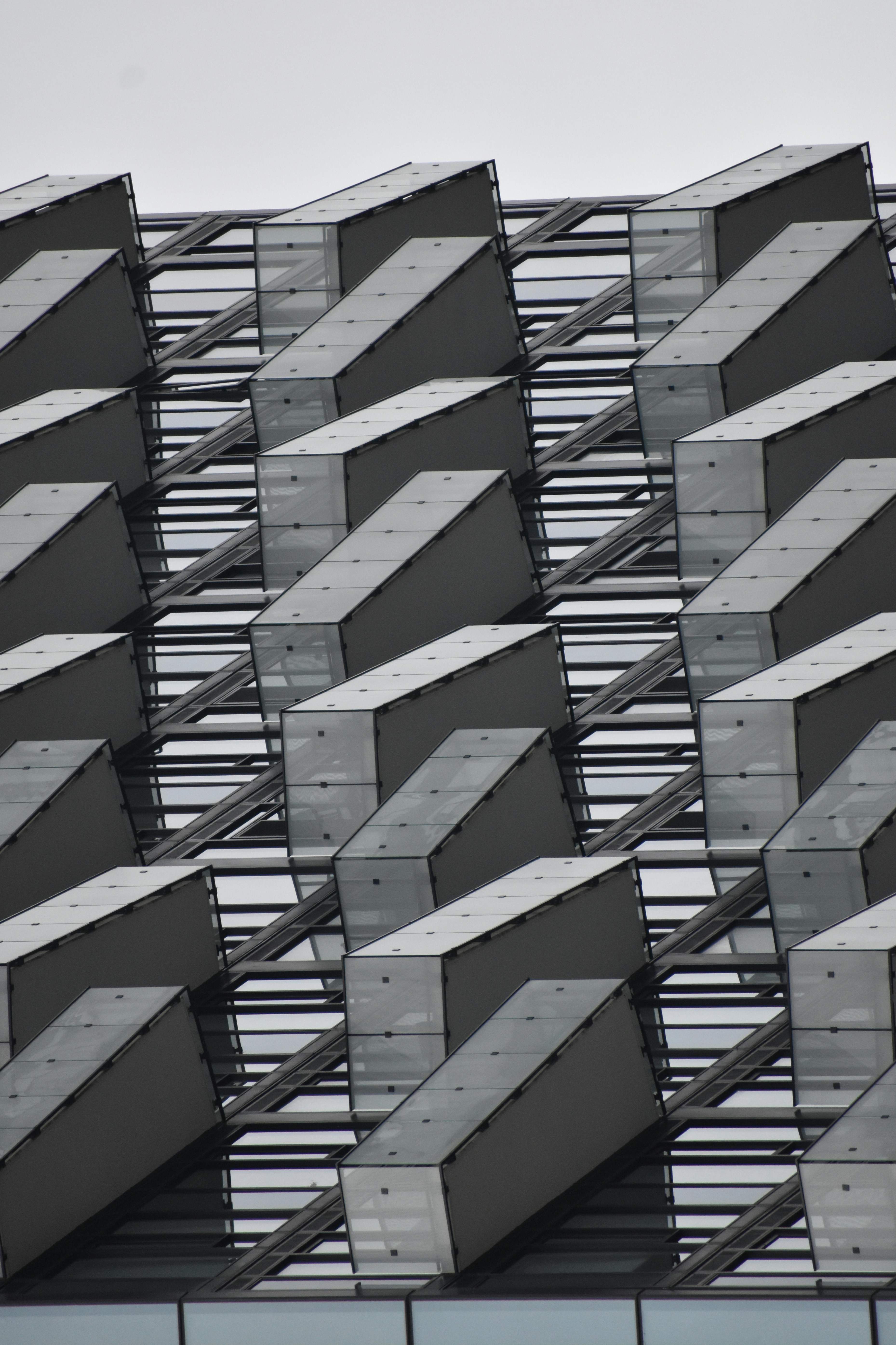 Angled glass and metal panels form a modern building's facade.