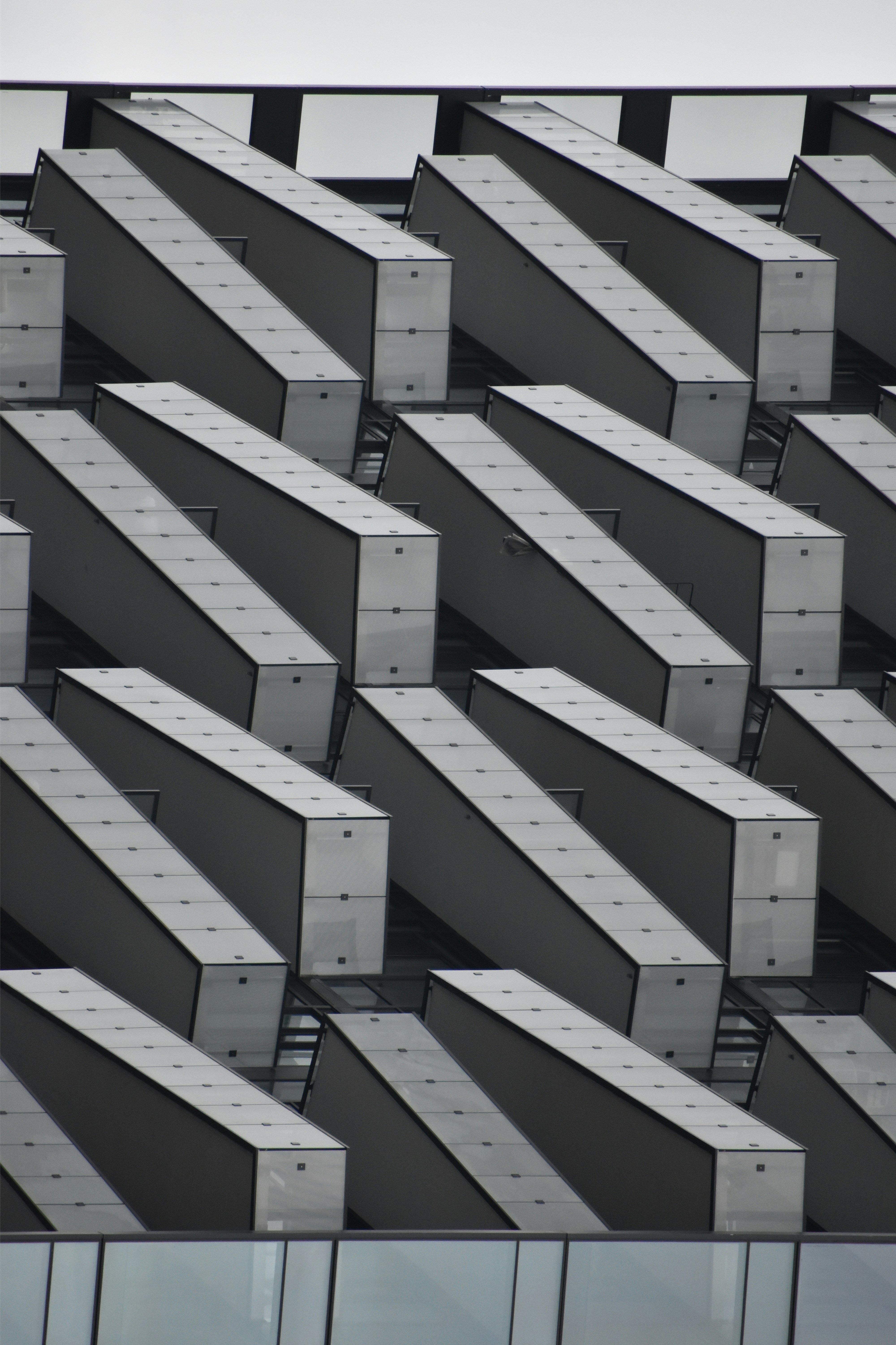 Modern building facade with repeating angled concrete elements.
