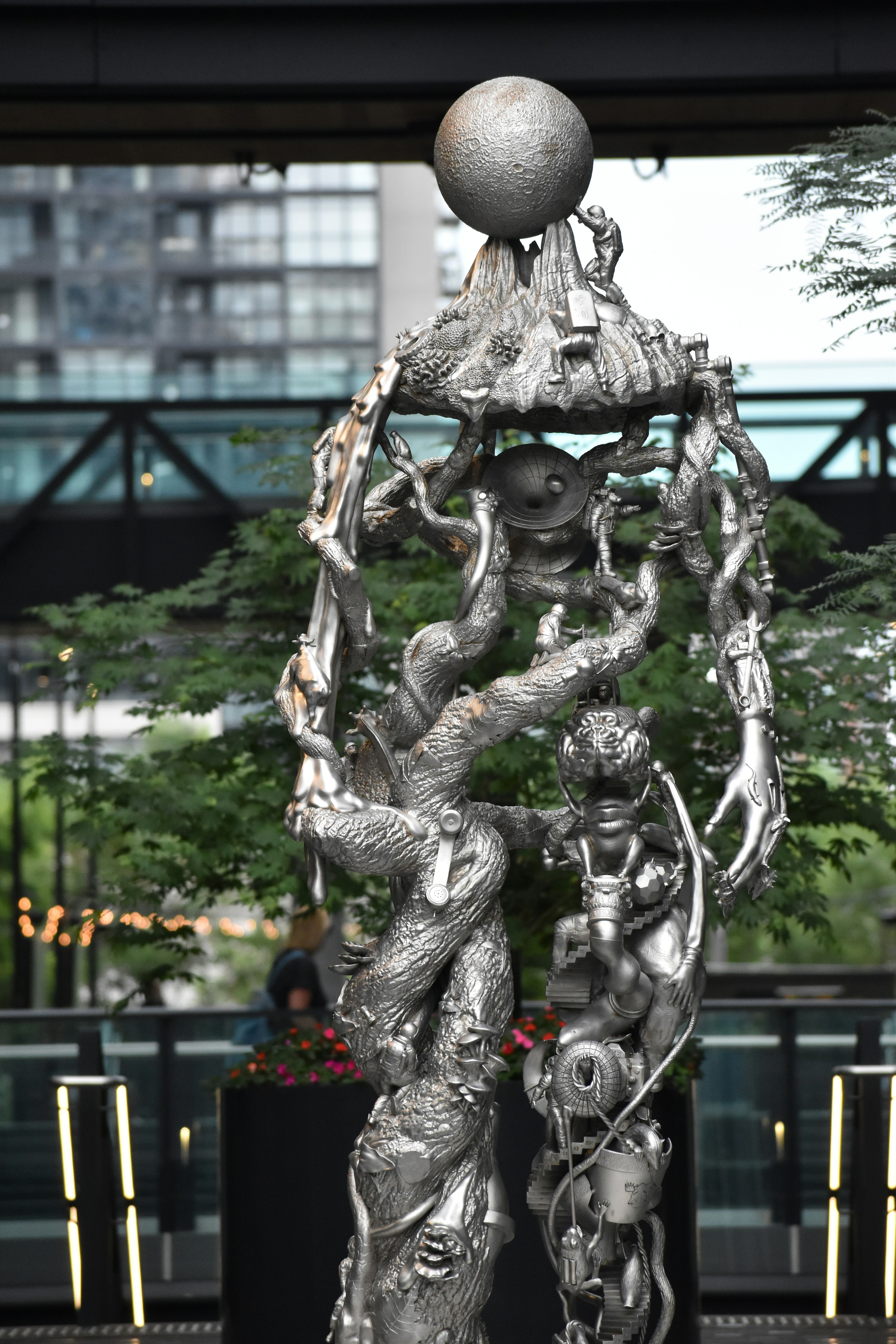A tall, intricate silver sculpture with a sphere on top.