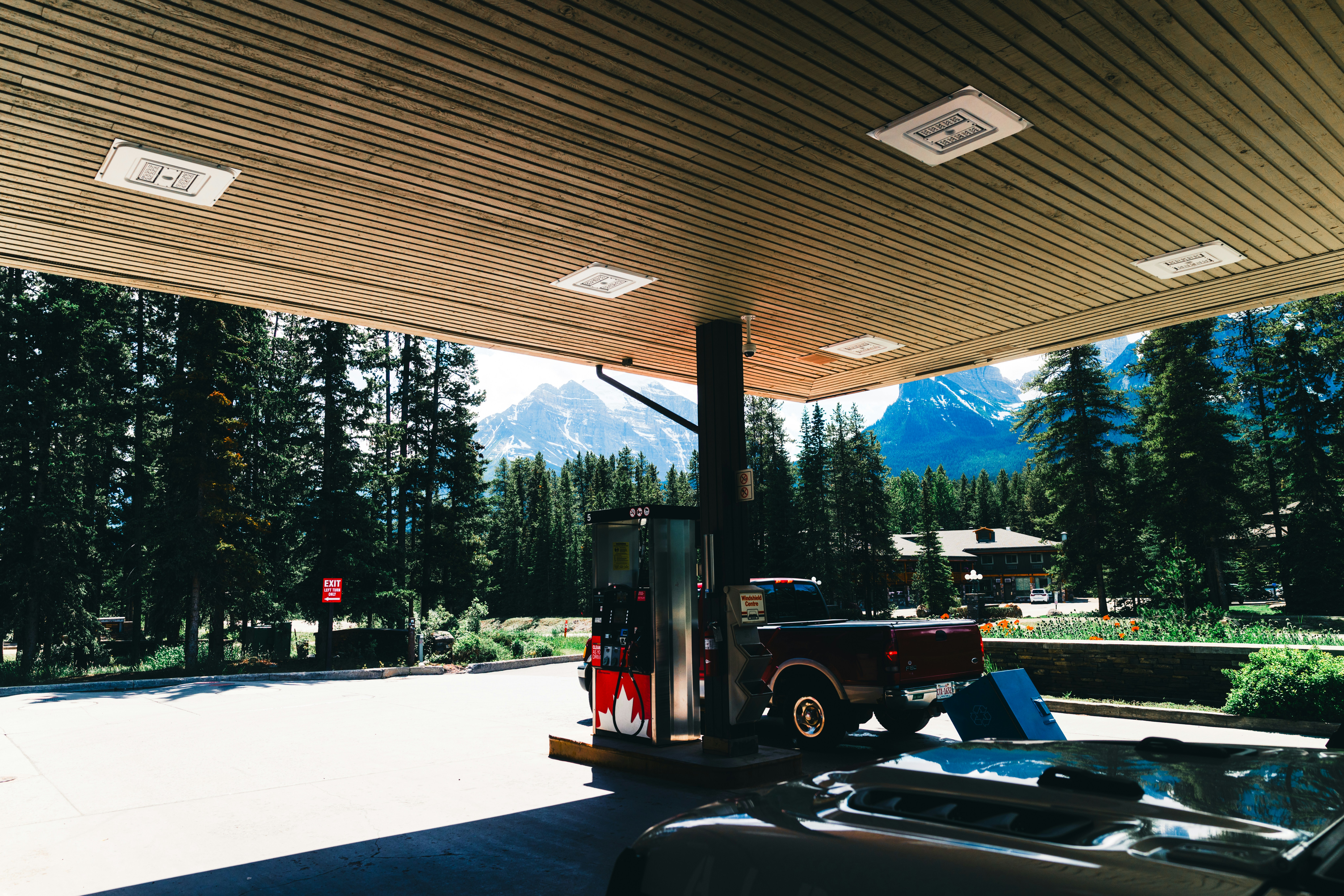 Gas station with mountains and pine trees in the background.