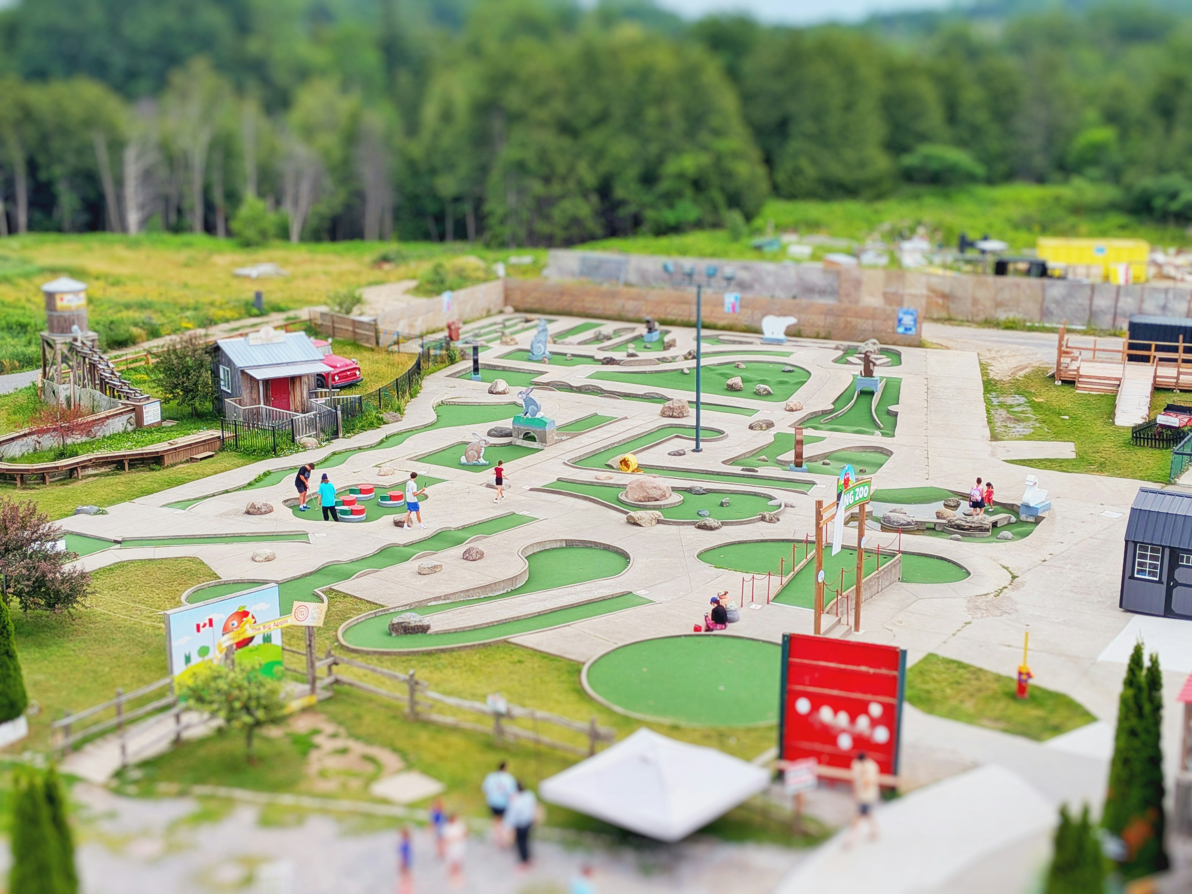 Outdoor miniature golf course with people playing.