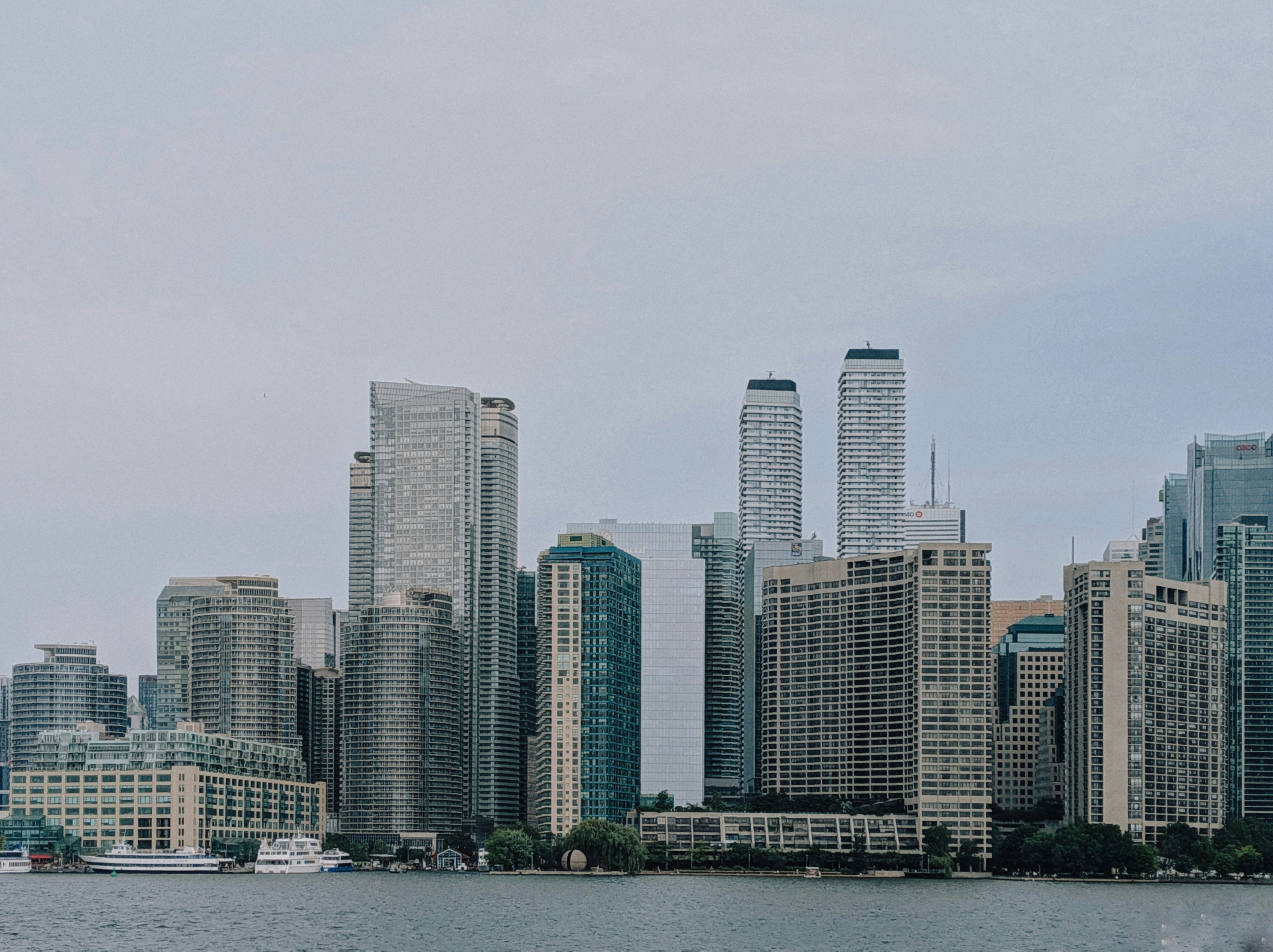 Modern city skyline with skyscrapers and water.