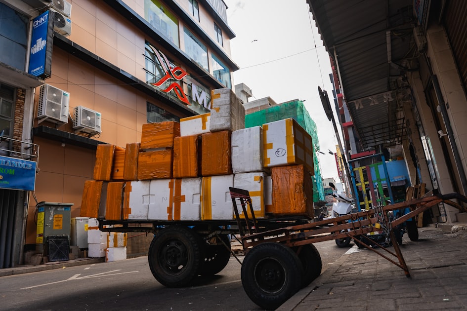 A cart loaded with many packages on a city street.