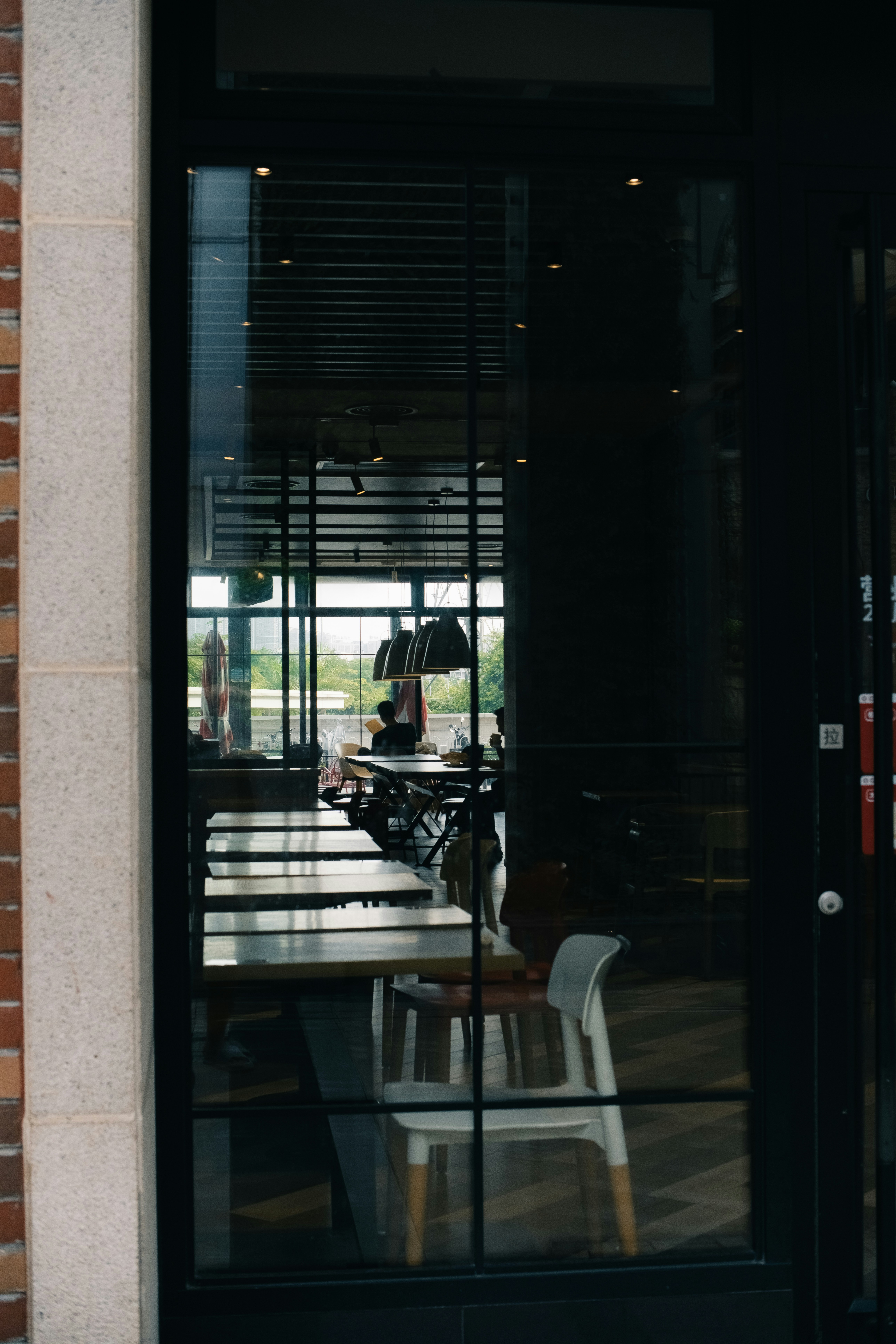 Glass door reflecting an indoor dining area and outdoor scene.