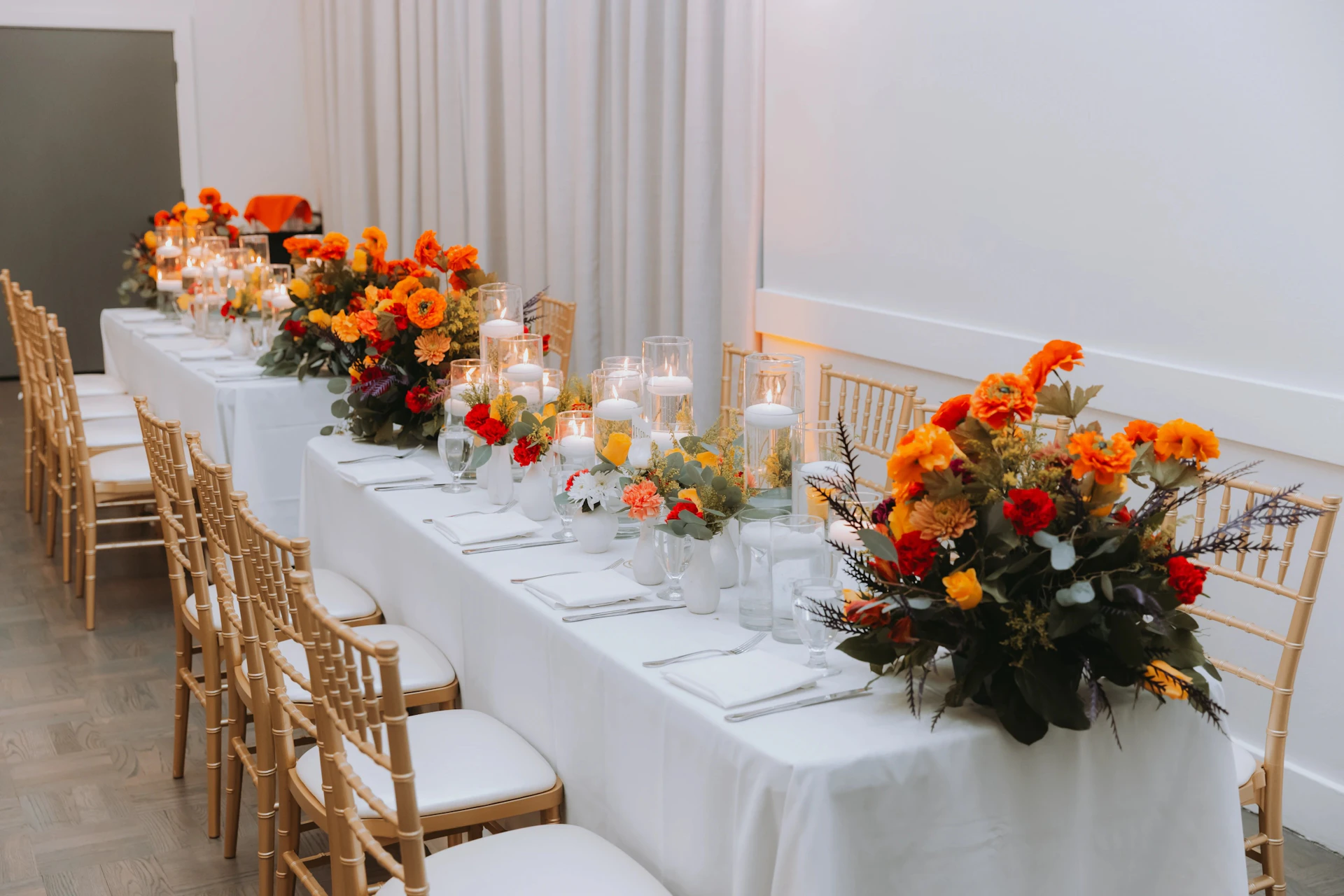 Elegant dining table set with orange flowers and candles