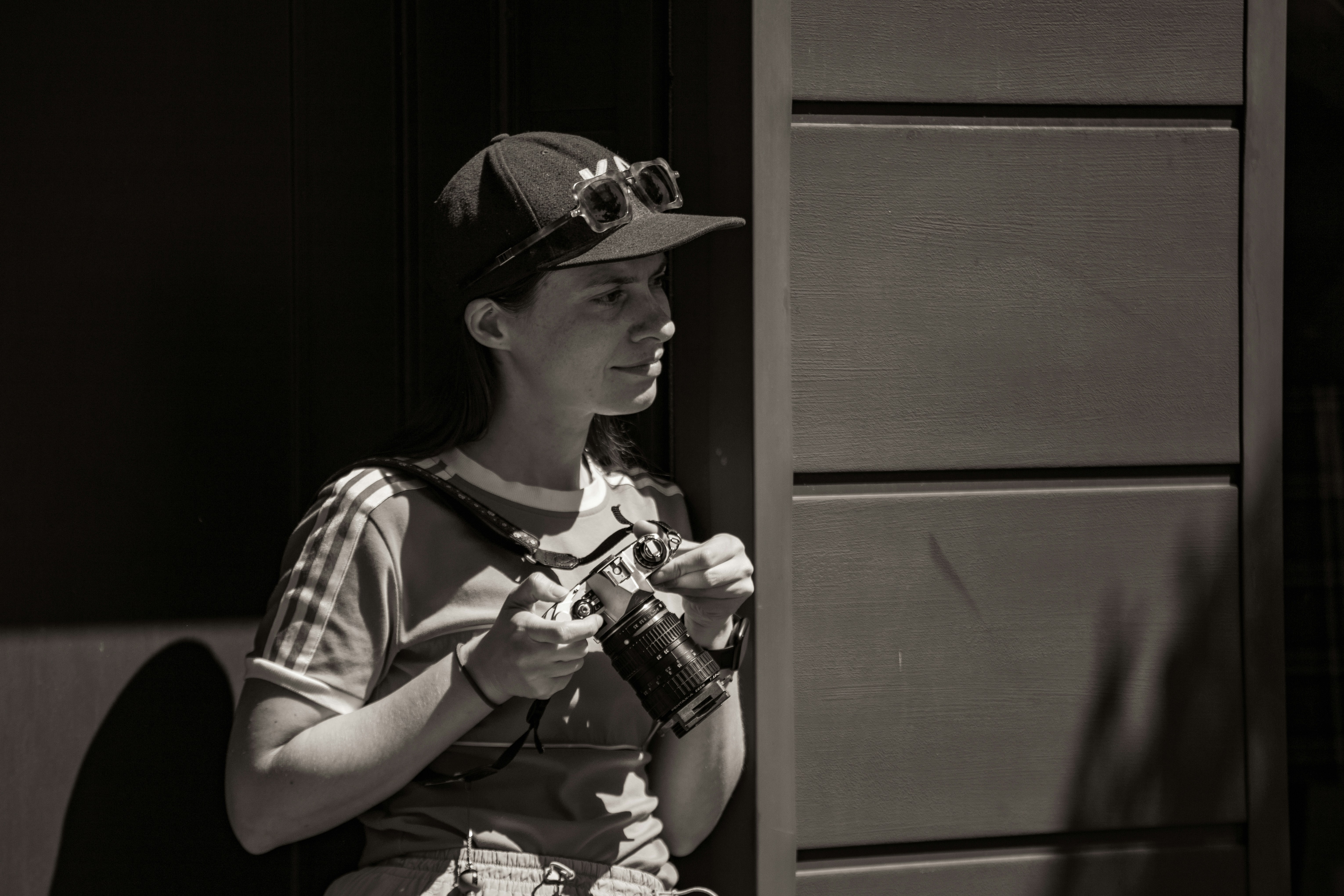 A woman in a cap and goggles holding a device.