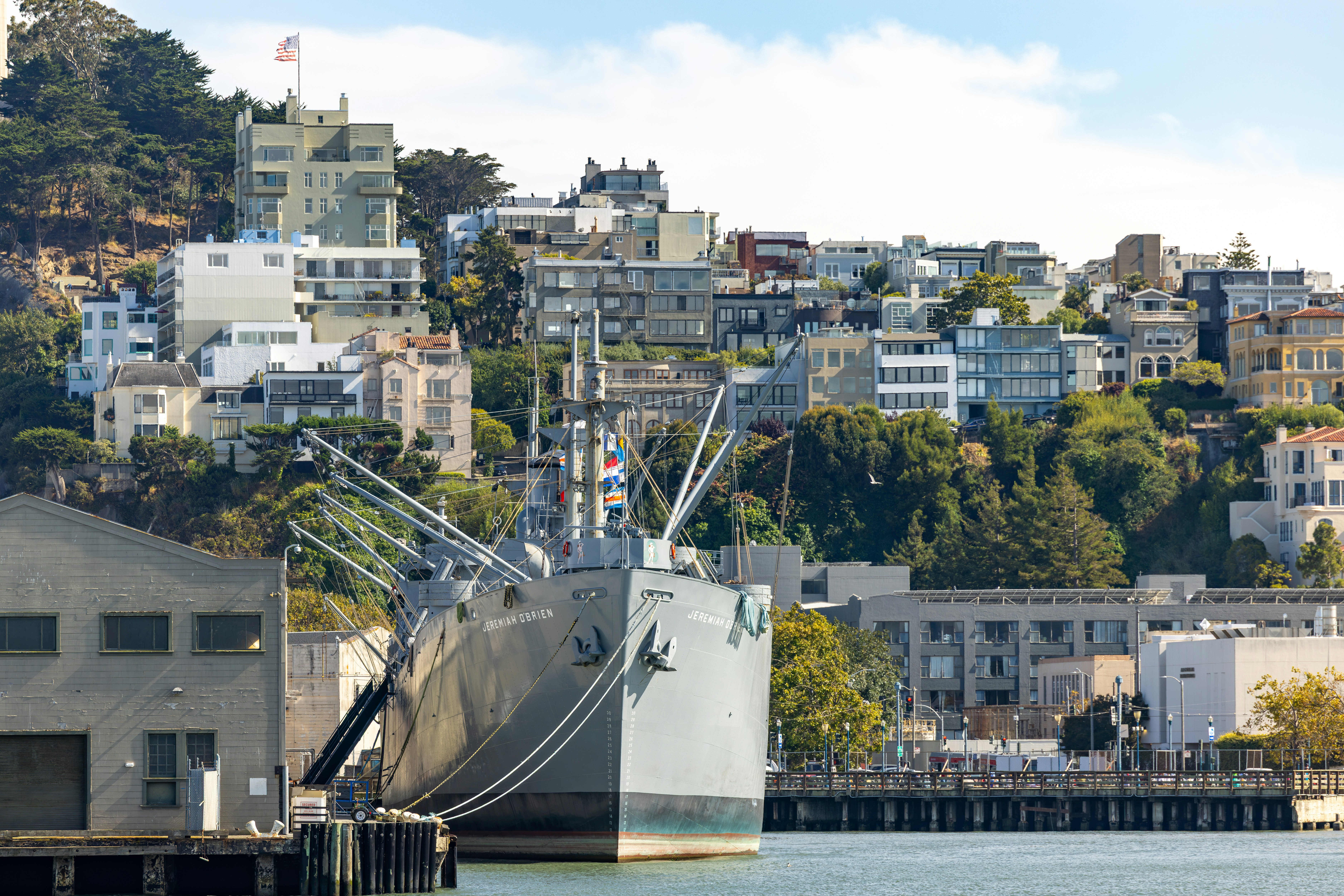 A large ship docked in a city harbor