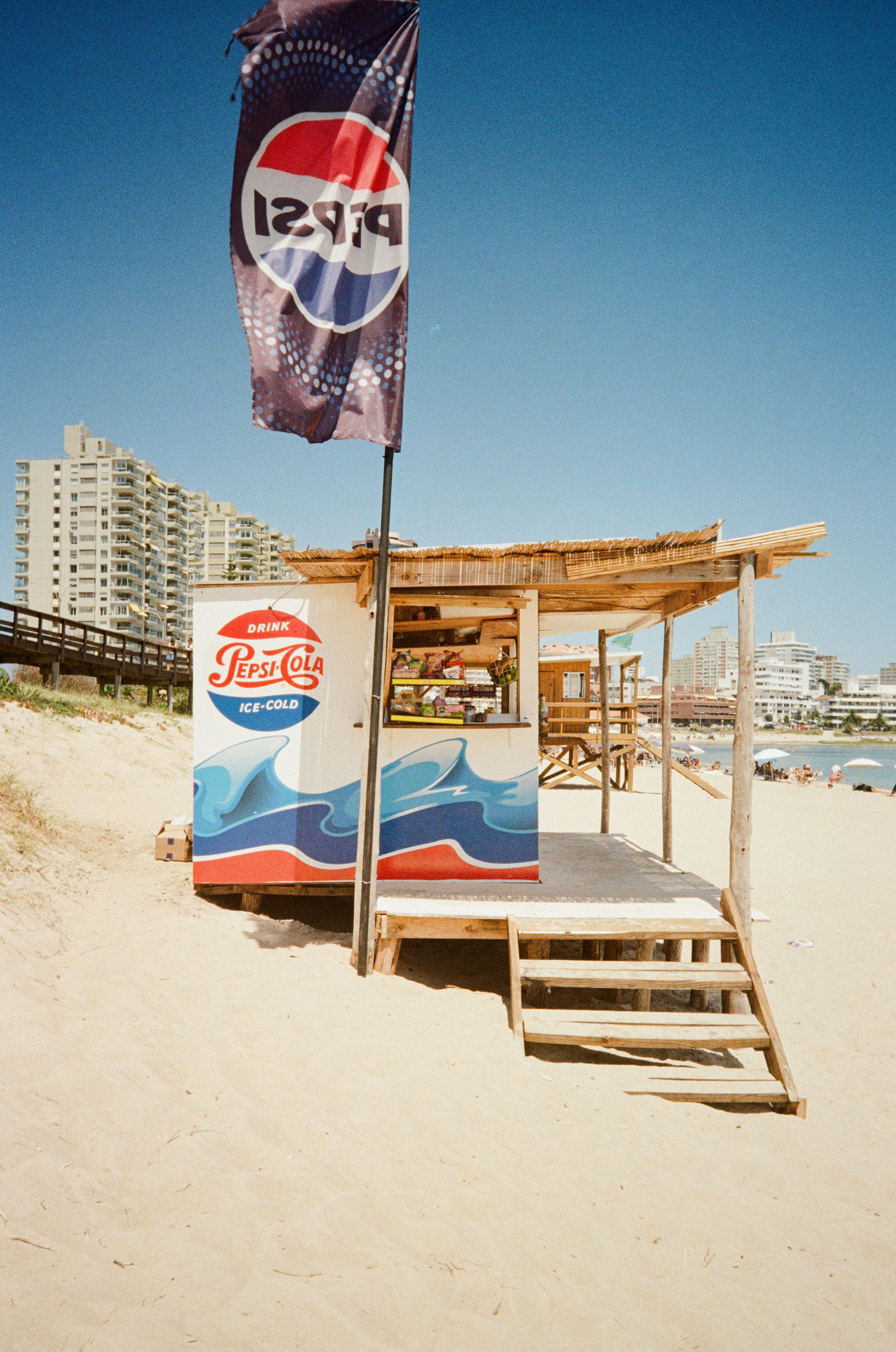 Pepsi beach stand with flag on a sandy beach.