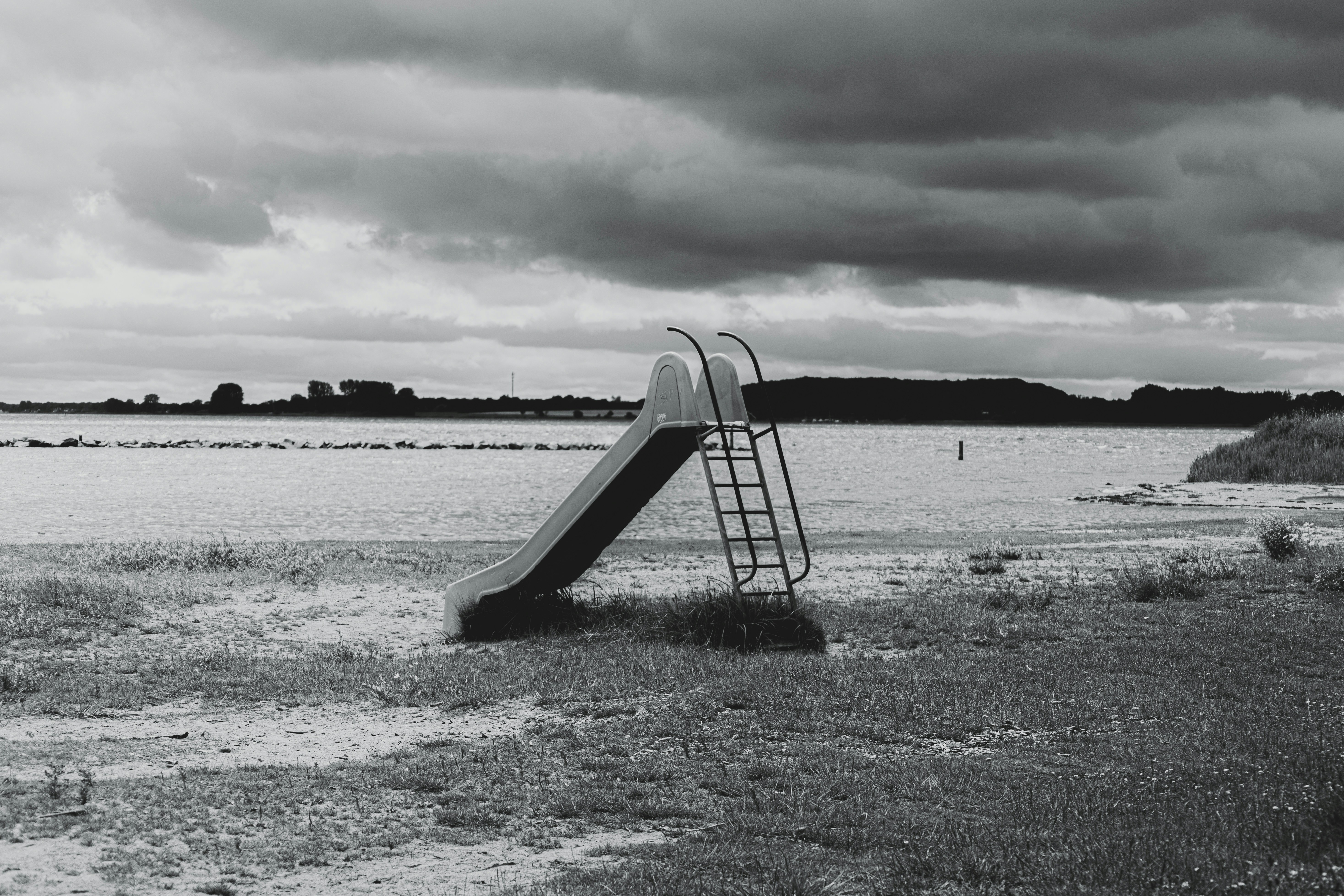 Space Abandoned Slide On A Lakeshore Under A Dark, Cloudy Sky. 4K Wallpaper #2992
