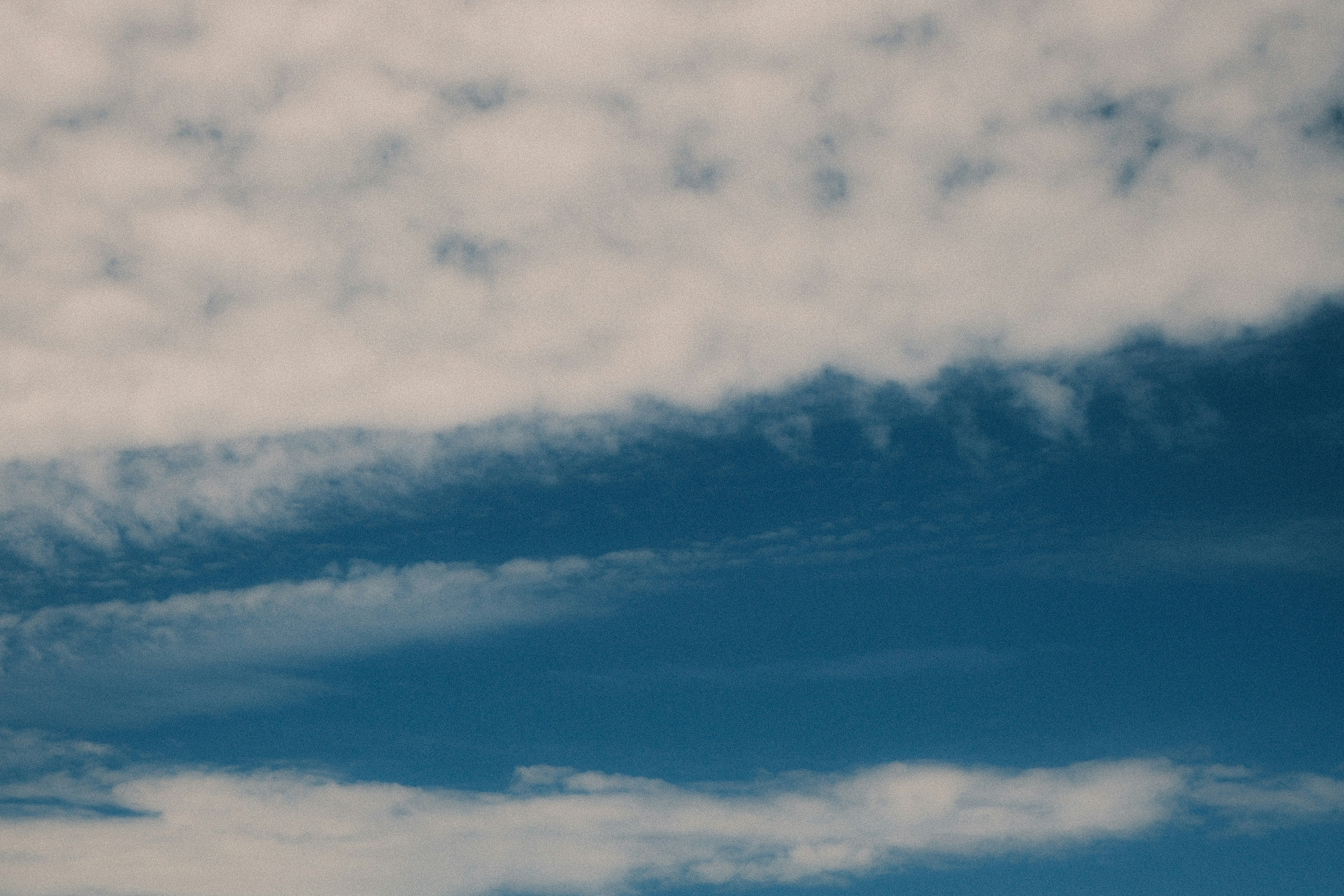Wispy white clouds against a vibrant blue sky.