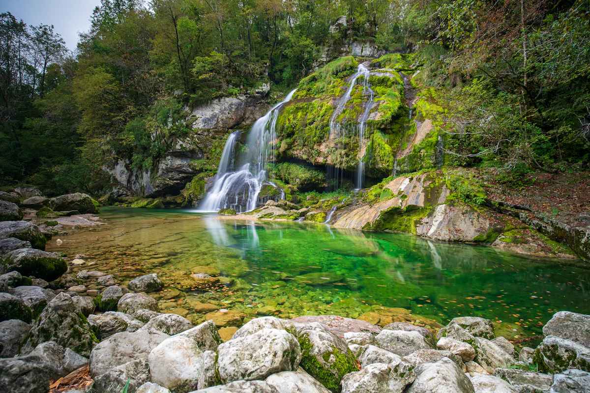 Cascada que cae sobre una poza de agua verde