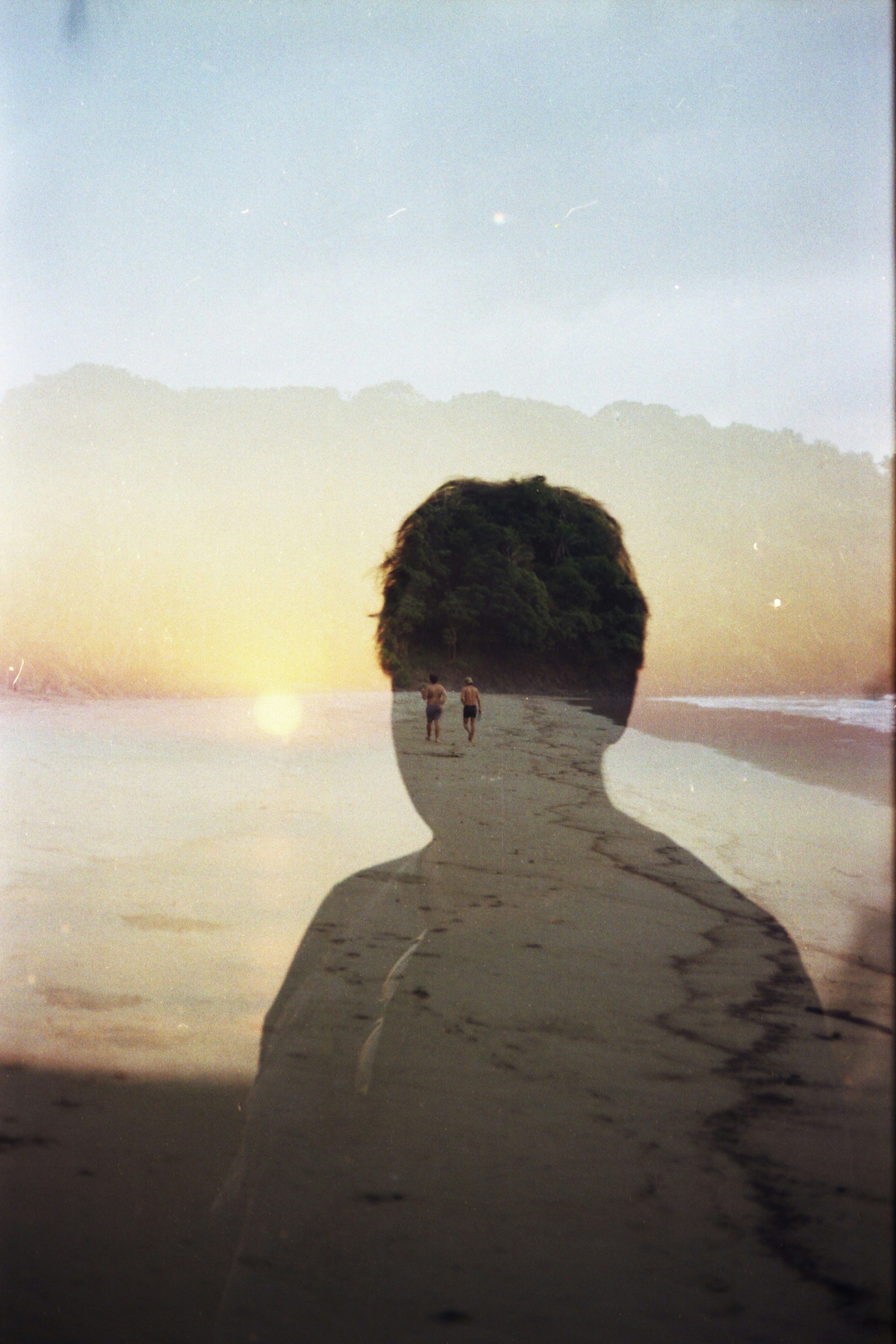 Person's silhouette superimposed on a serene sunset beach