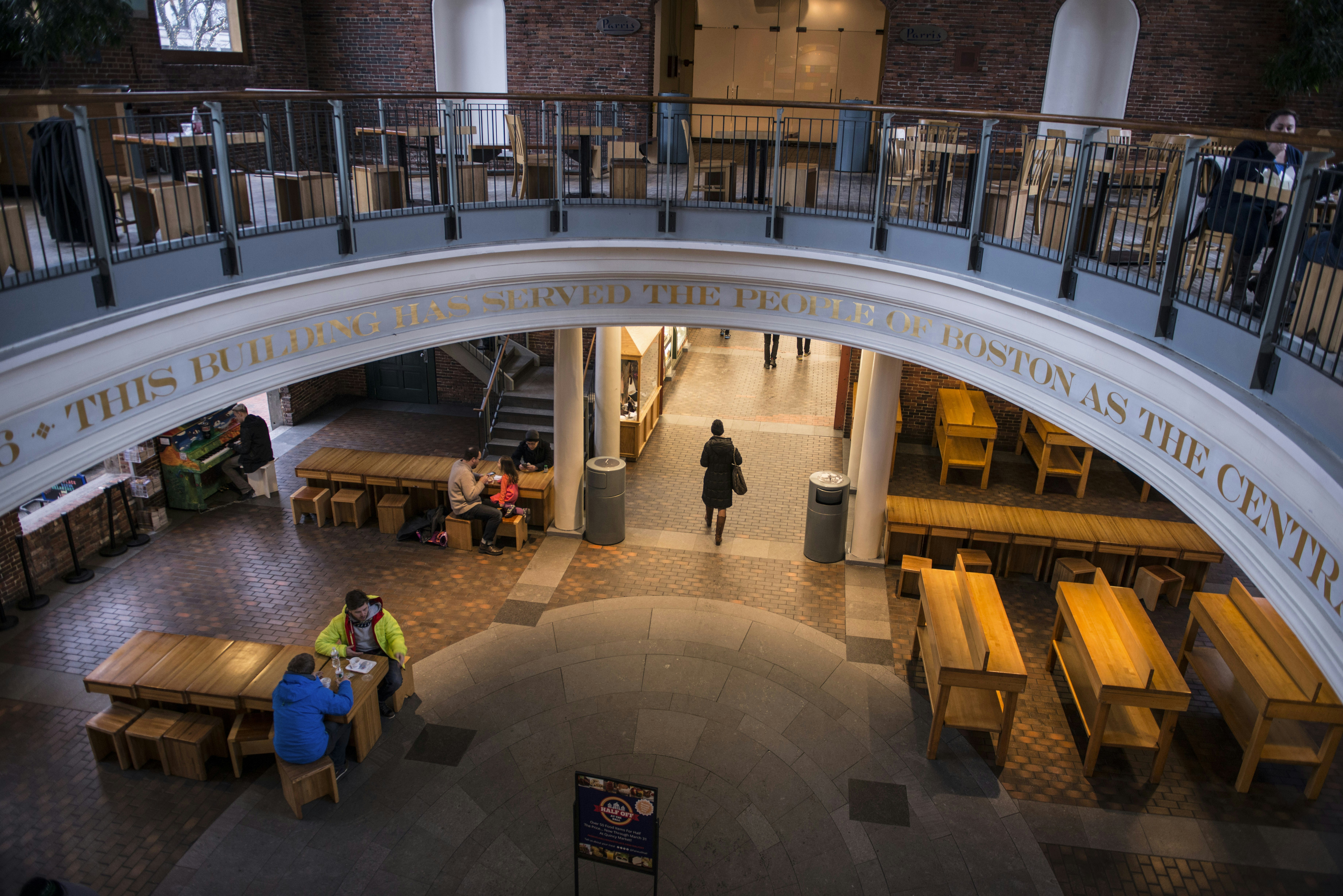 People gathered in a large, multi-level hall with tables.