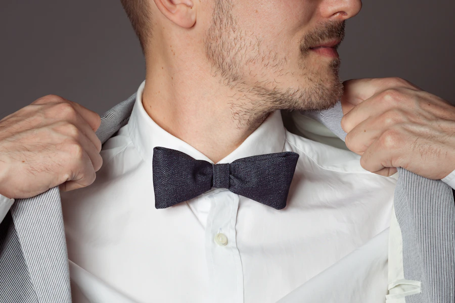 Man adjusting his suit jacket and bow tie, suit and tuxedo enhancements near Turnersville, NJ