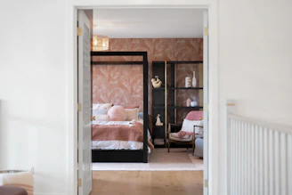 Stylish bedroom with a four-poster bed and decorative shelving.