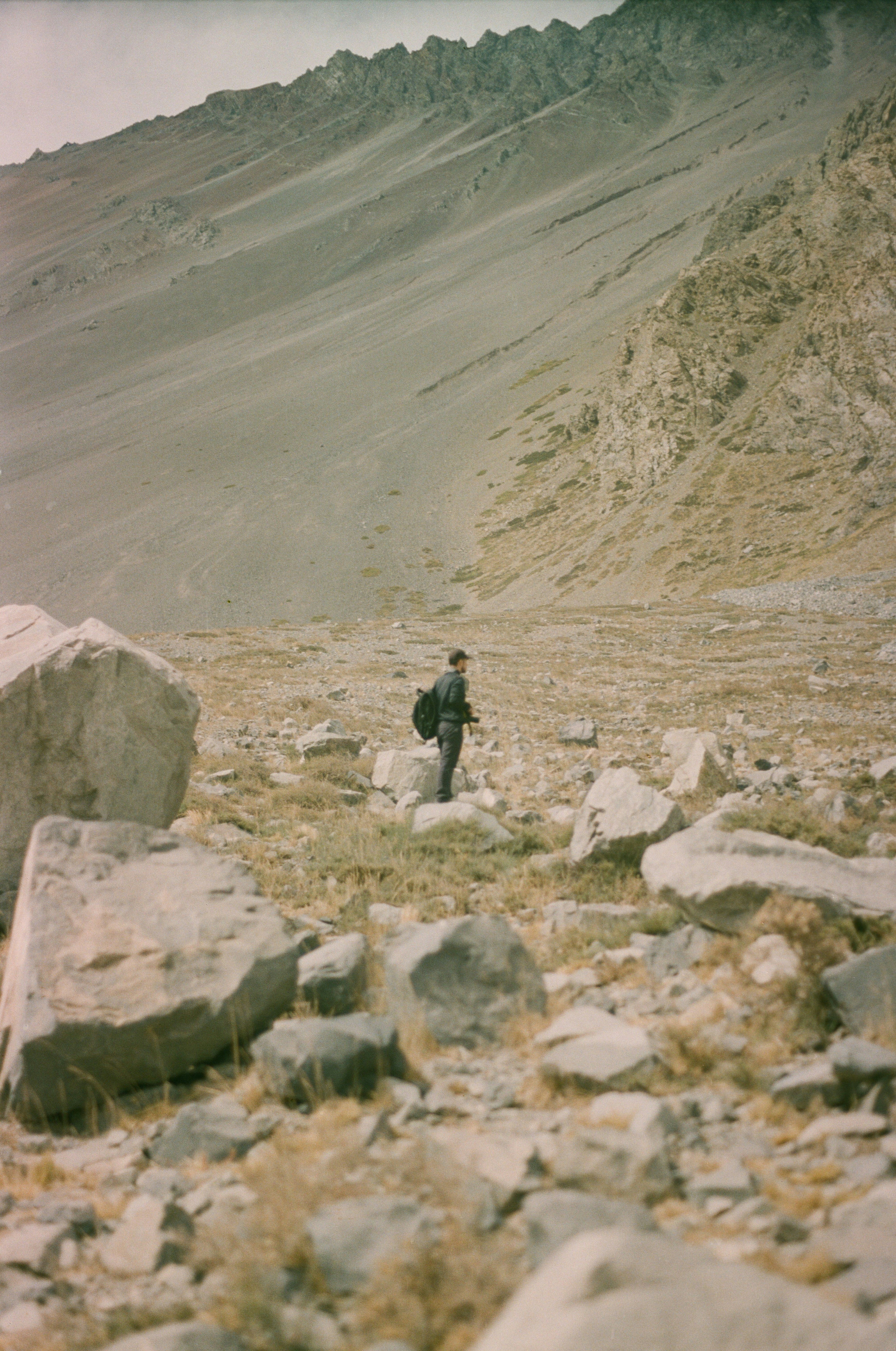 A person stands in a rocky mountain valley.