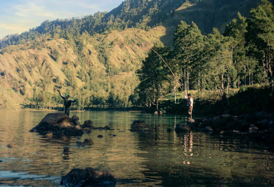 Two people fishing on a lake with trees