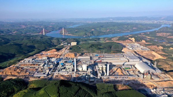 Complejo industrial visto desde el aire junto a un río y un puente colgante rojo, escenario de la agencia de SEO en México