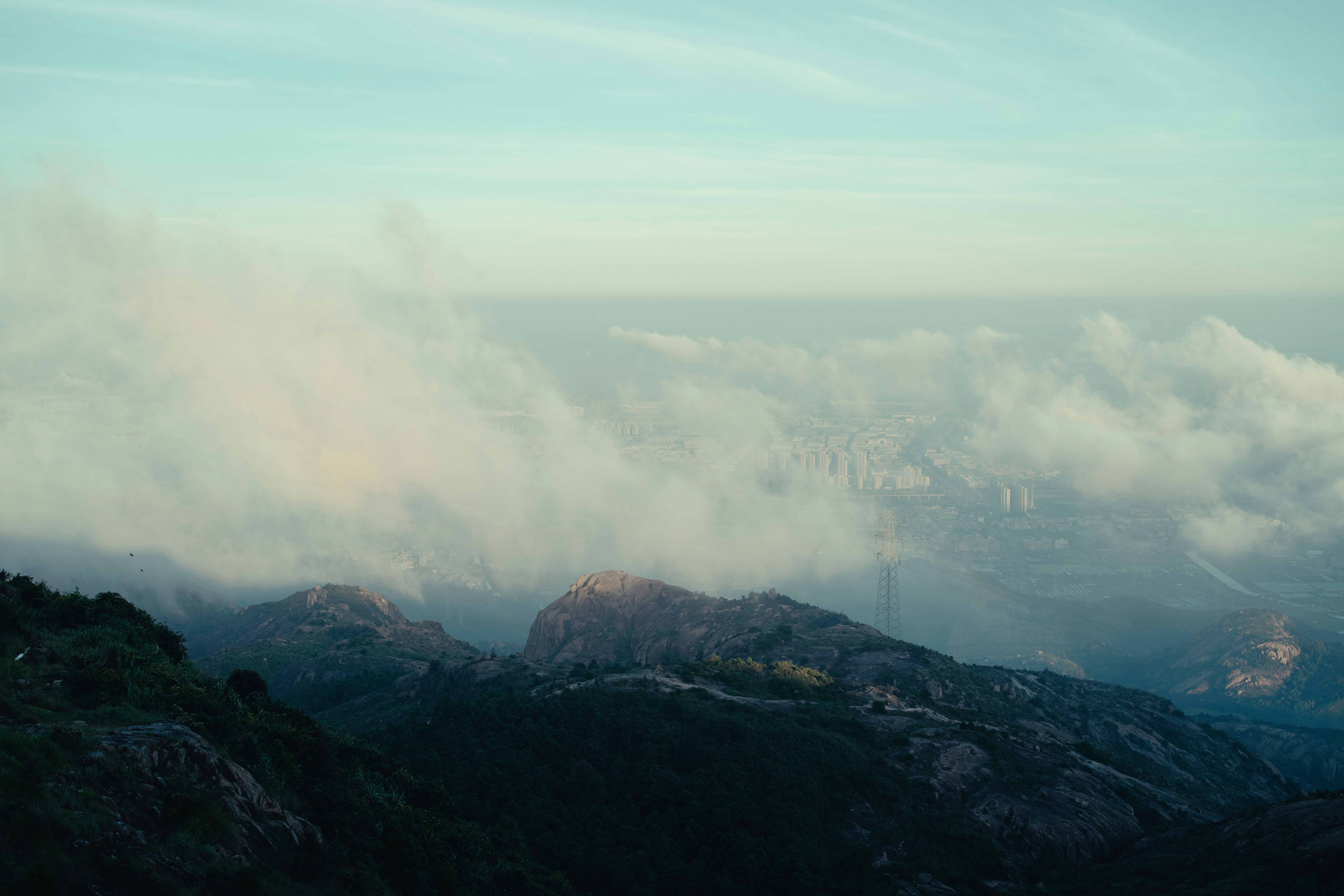 Misty mountains with clouds and a distant city