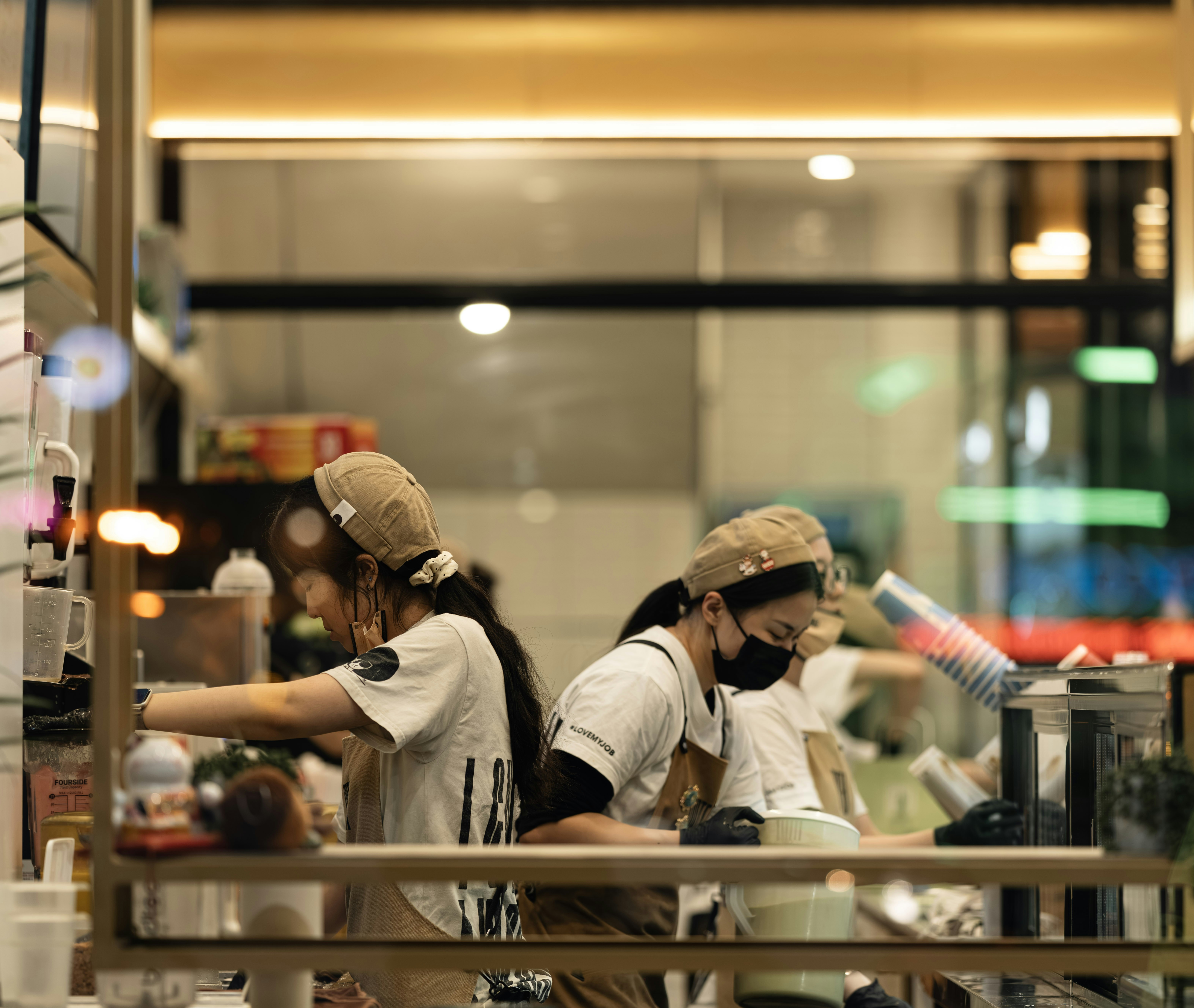 Dua anggota staf menyiapkan minuman di sebuah kafe.