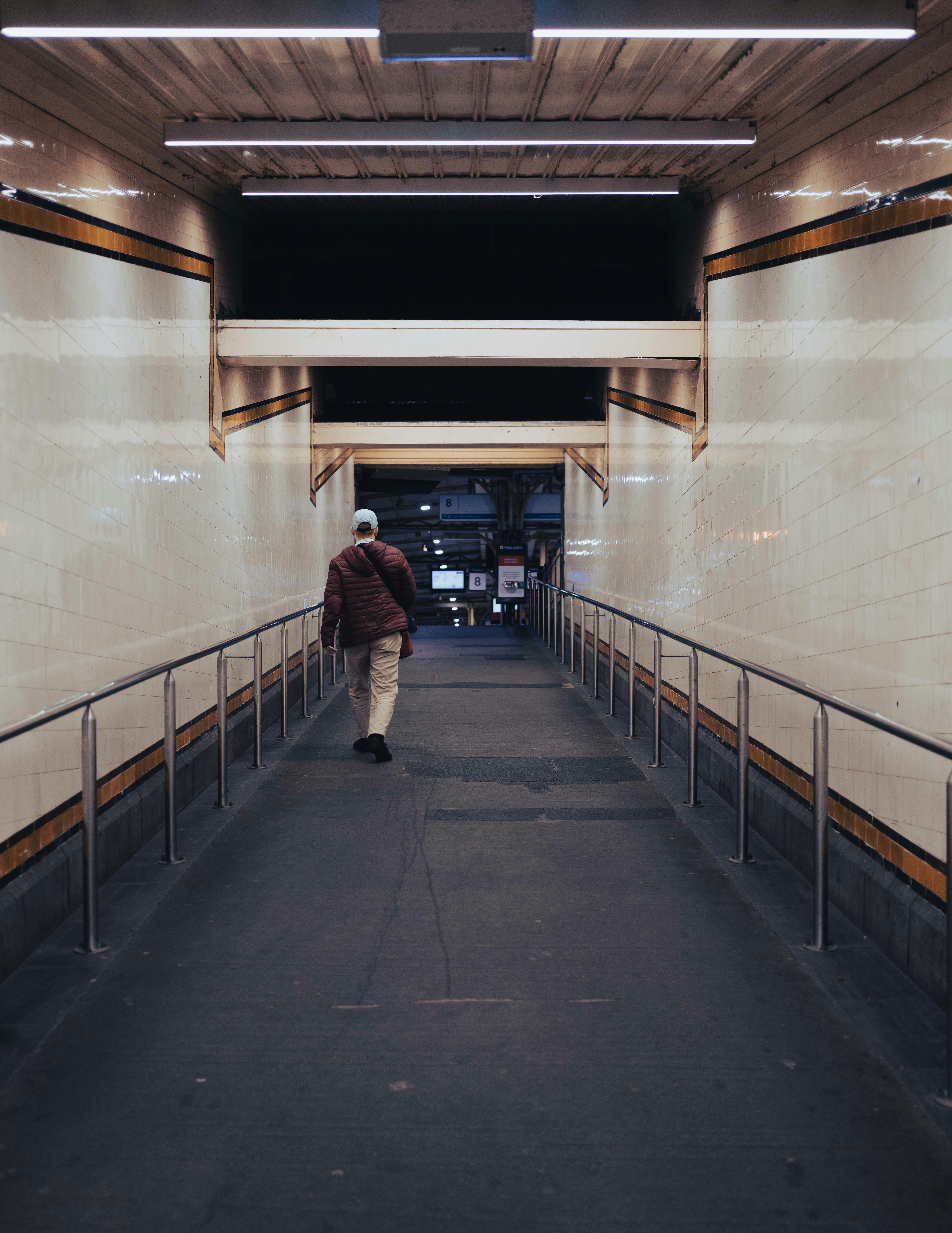 A person walks down a brightly lit underground walkway.