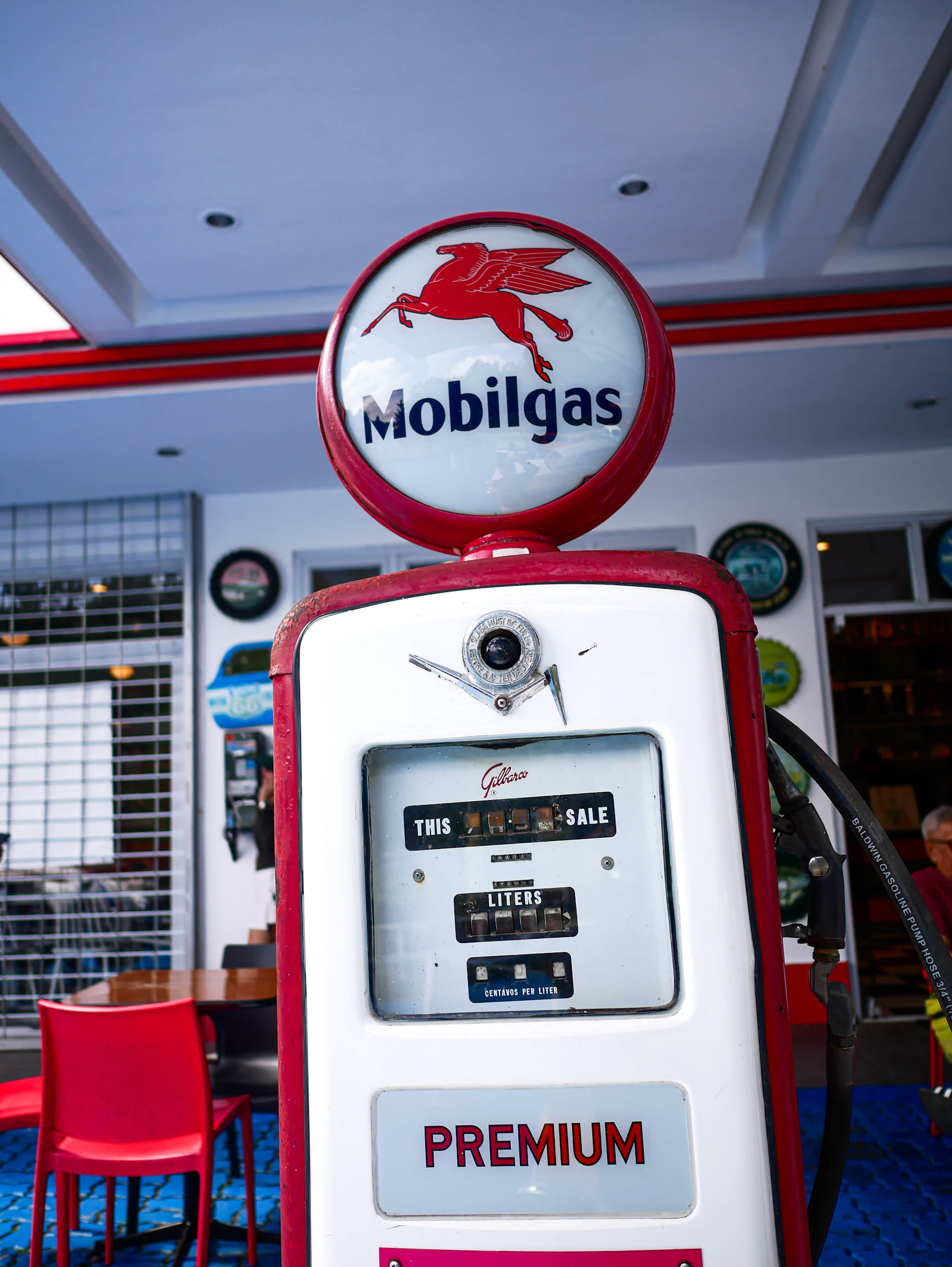 A red and white Mobilgas pump with a round glass globe on top showing a red winged horse