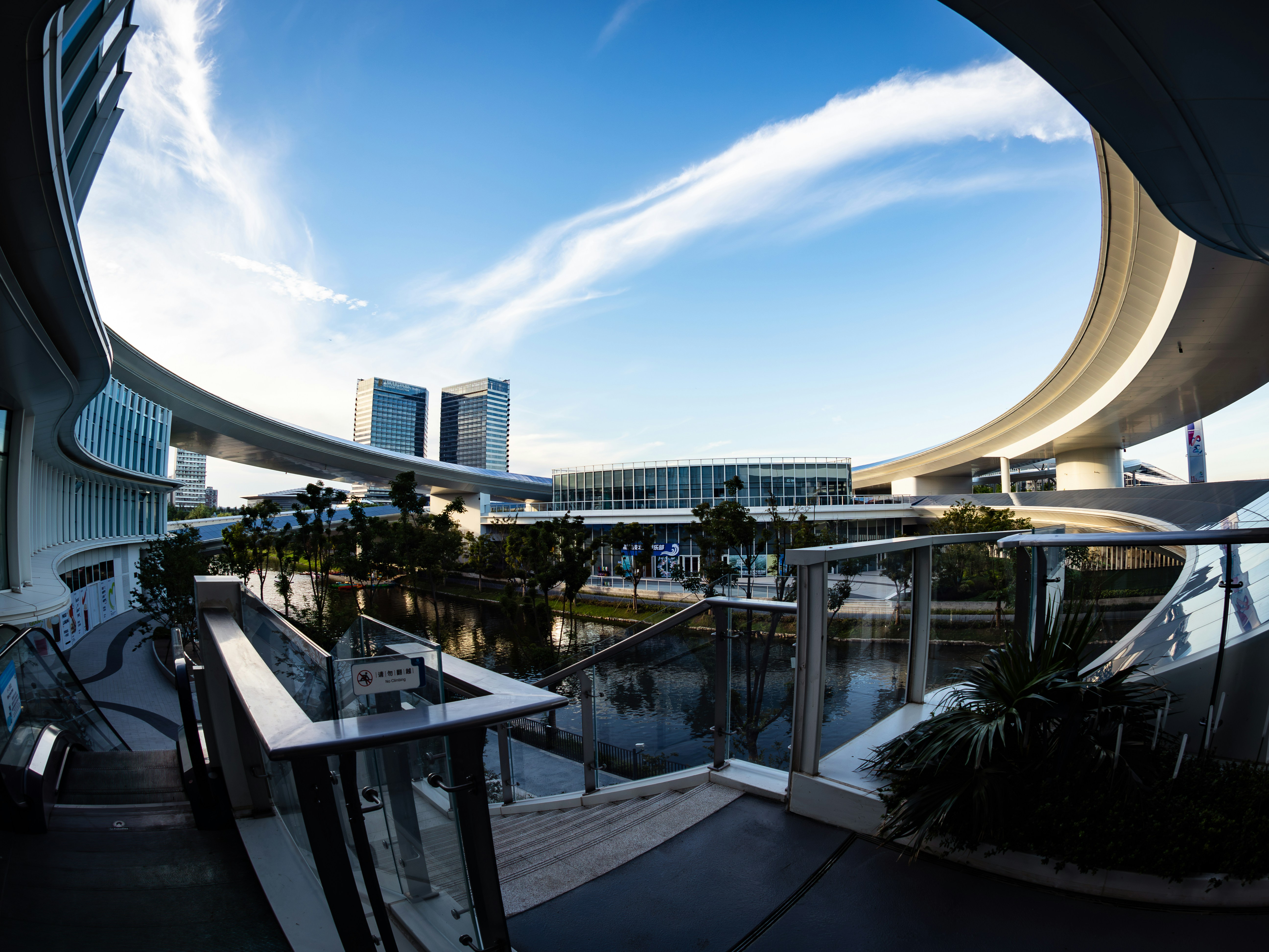 Modern curved architecture overlooking water under blue sky