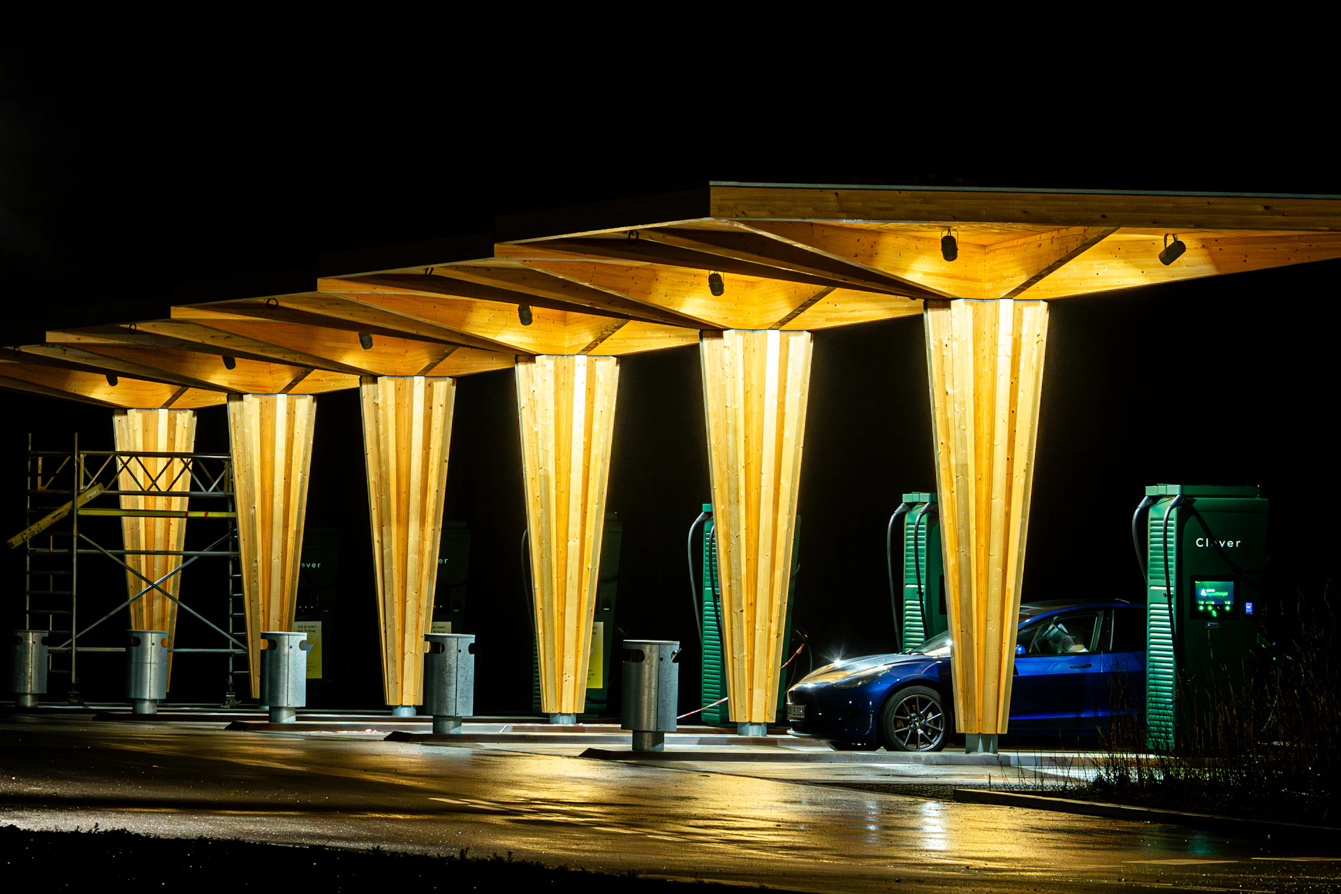 Illuminated modern ev charging station with a car at night.