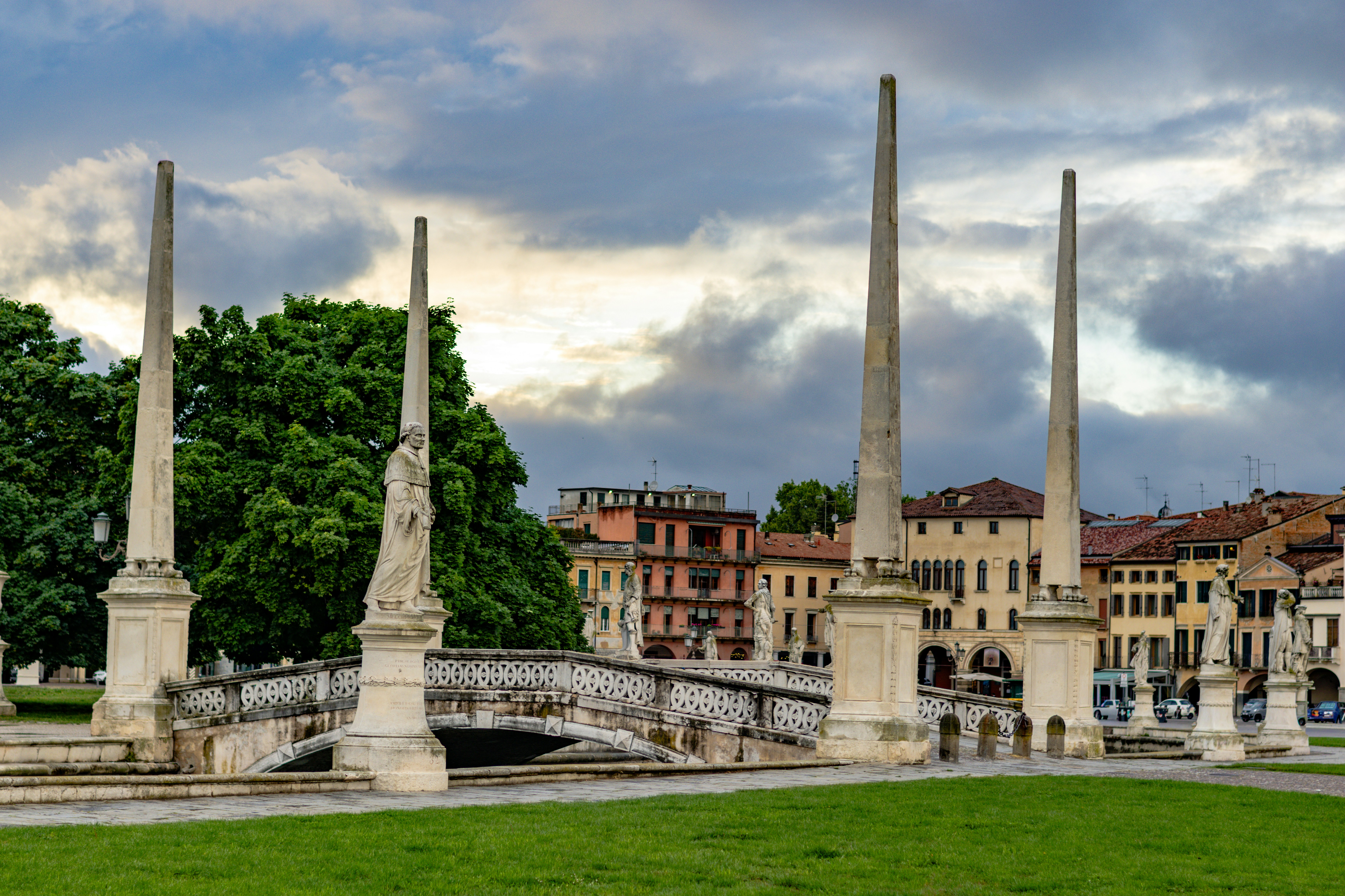 Historic italian square with obelisks, statues, and a bridge