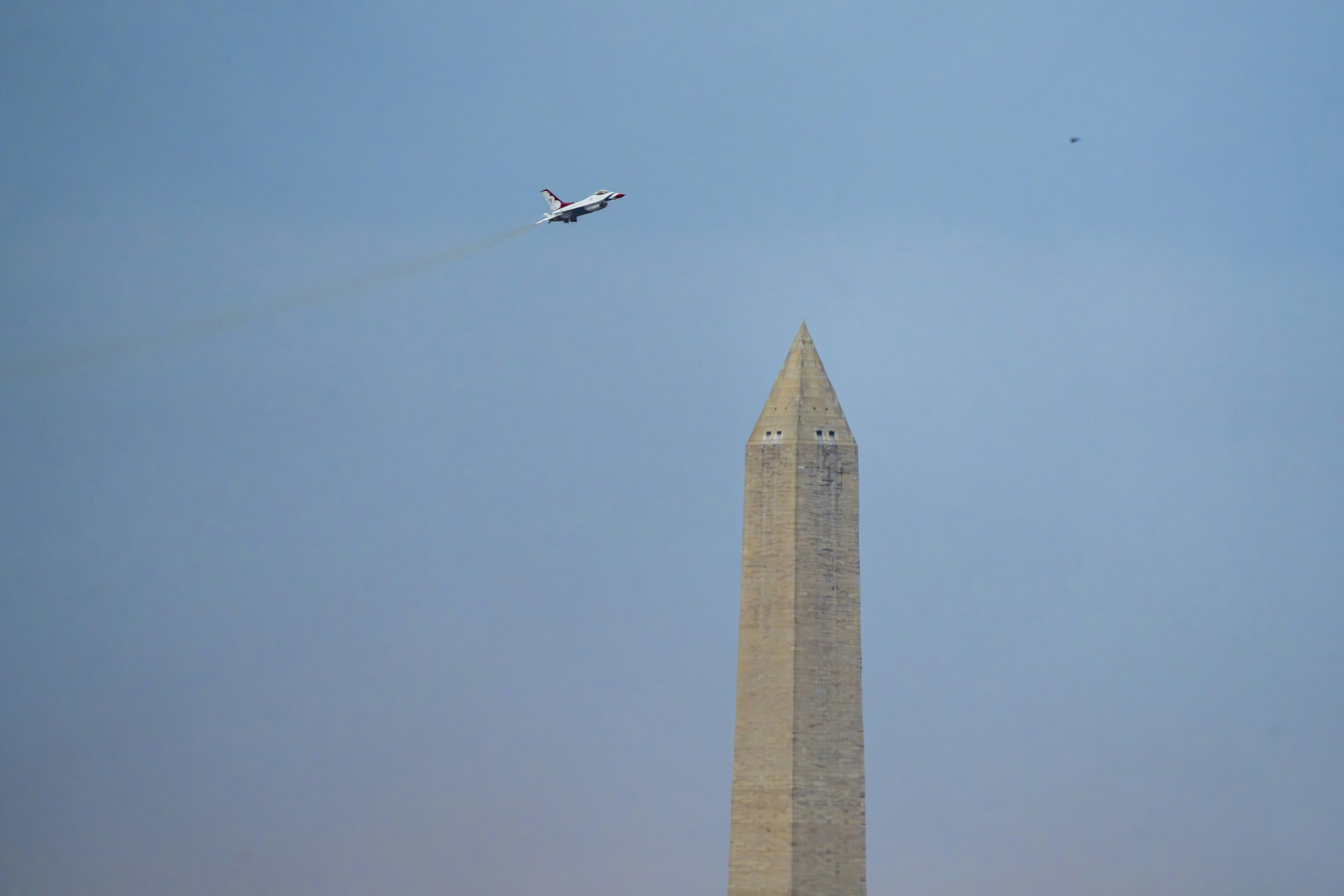 A jet flies over the washington monument