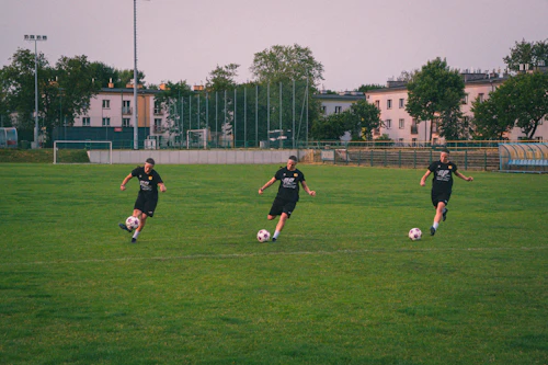 Soccer players dribbling on a green field