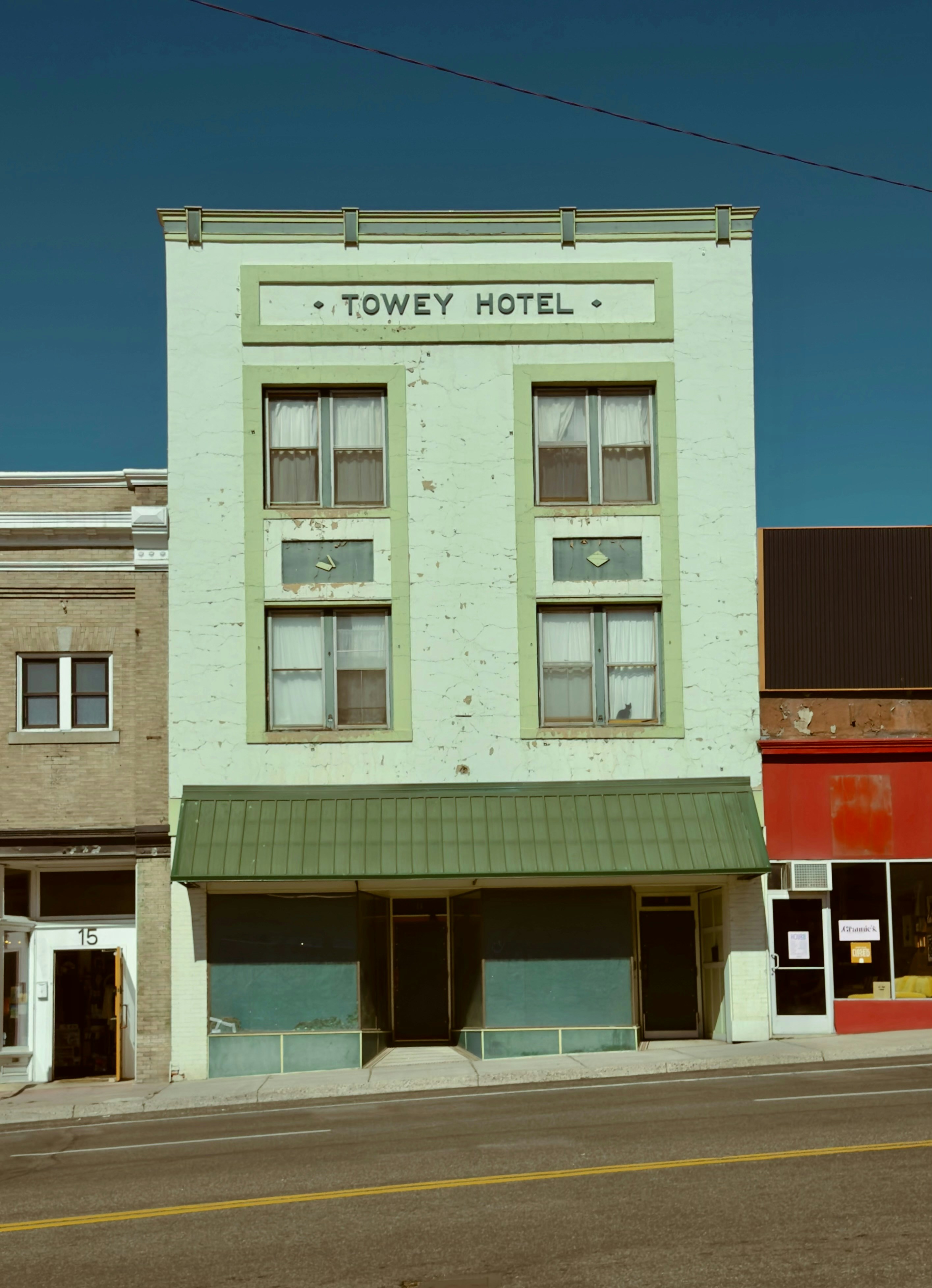 Historic towey hotel building with a green awning.