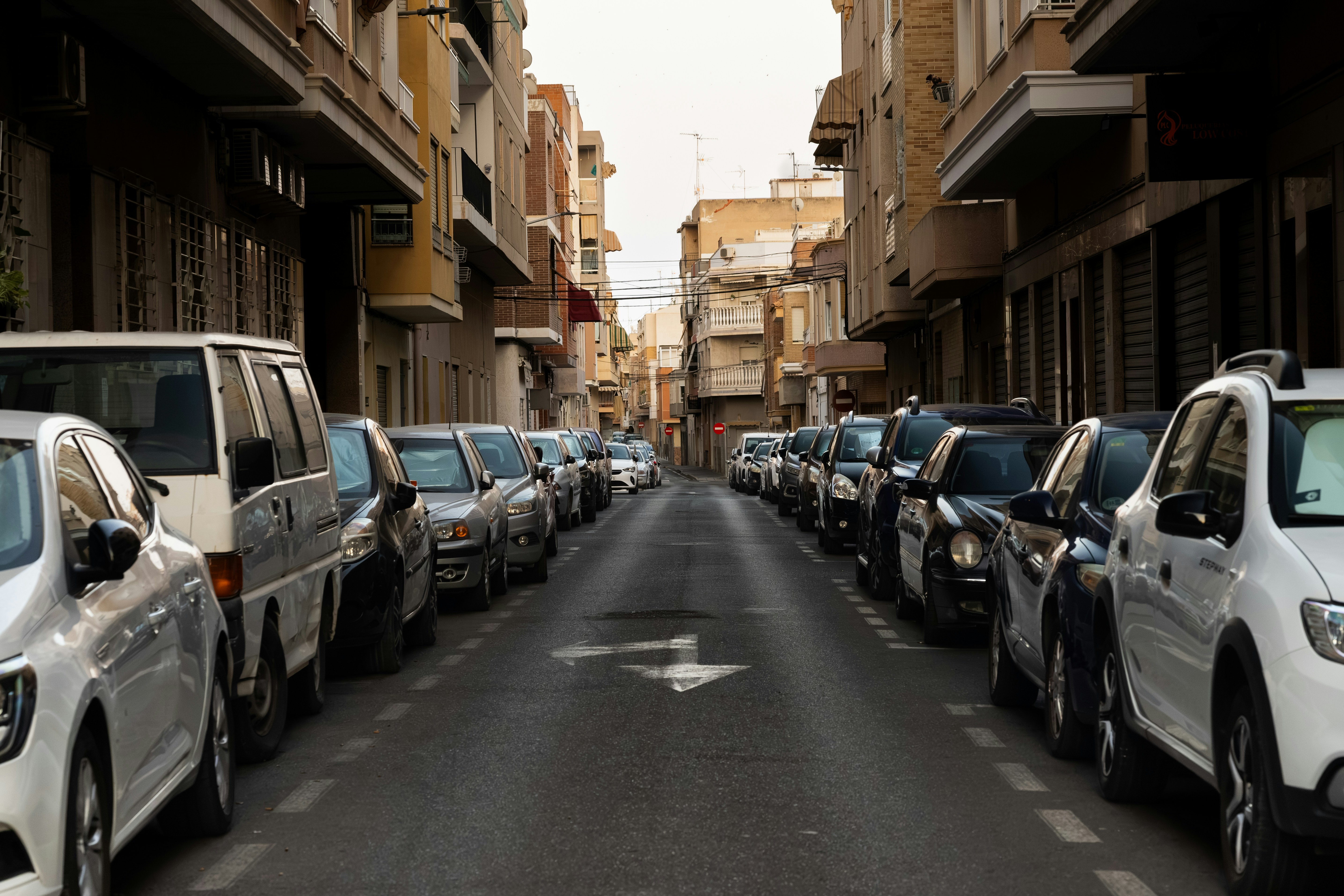 Cars Parked Along A Narrow Street Between Buildings. 4K Wallpaper #2688