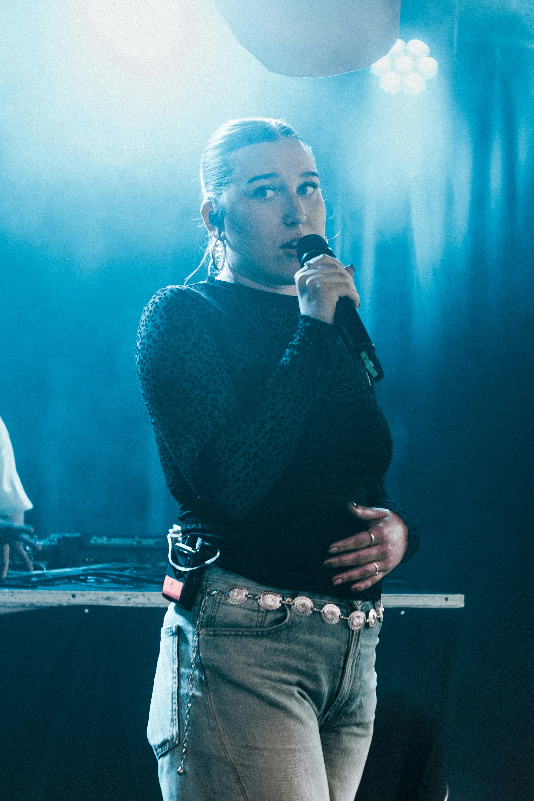 Female singer performing on stage with a microphone