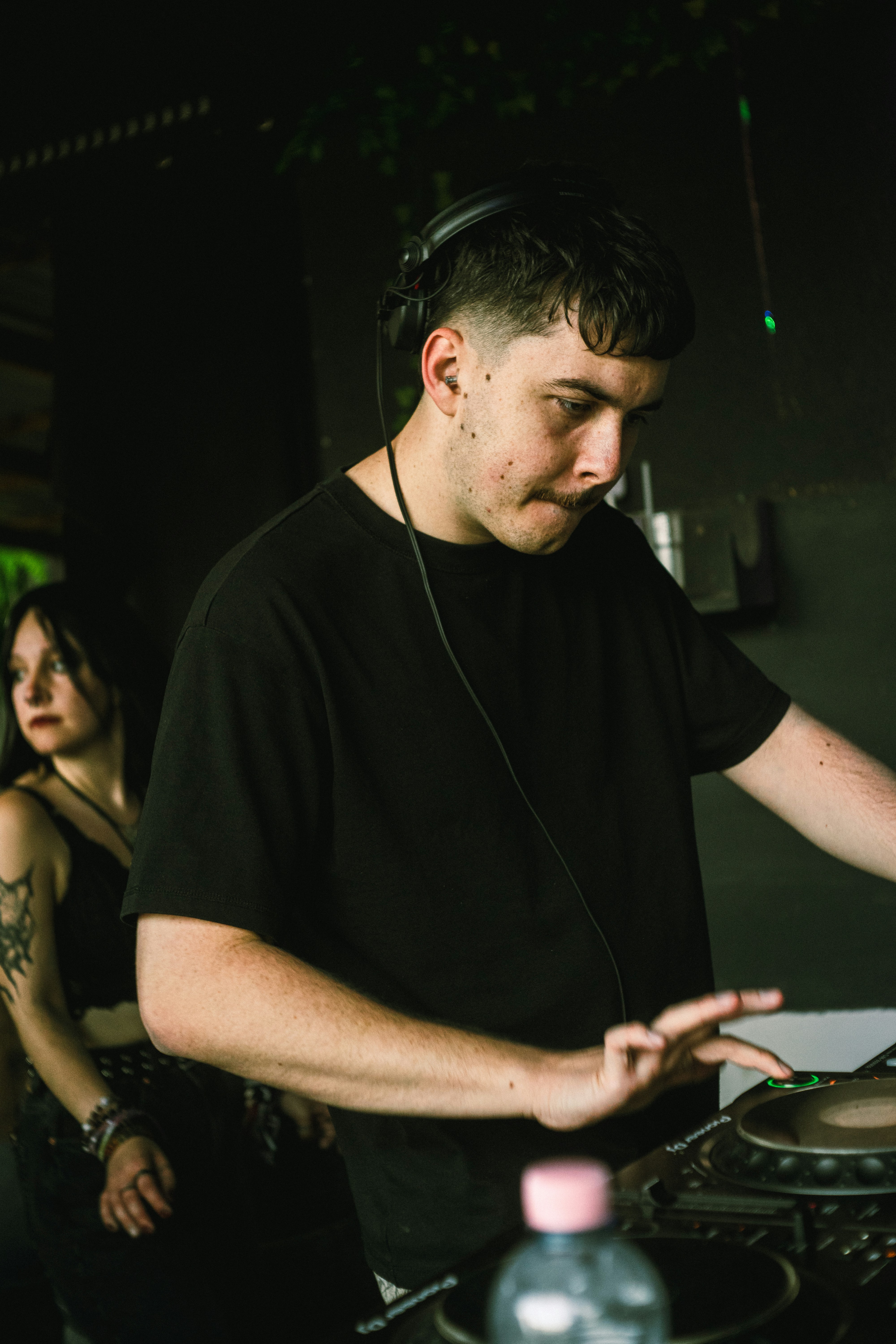 A man djing with headphones in a dark club