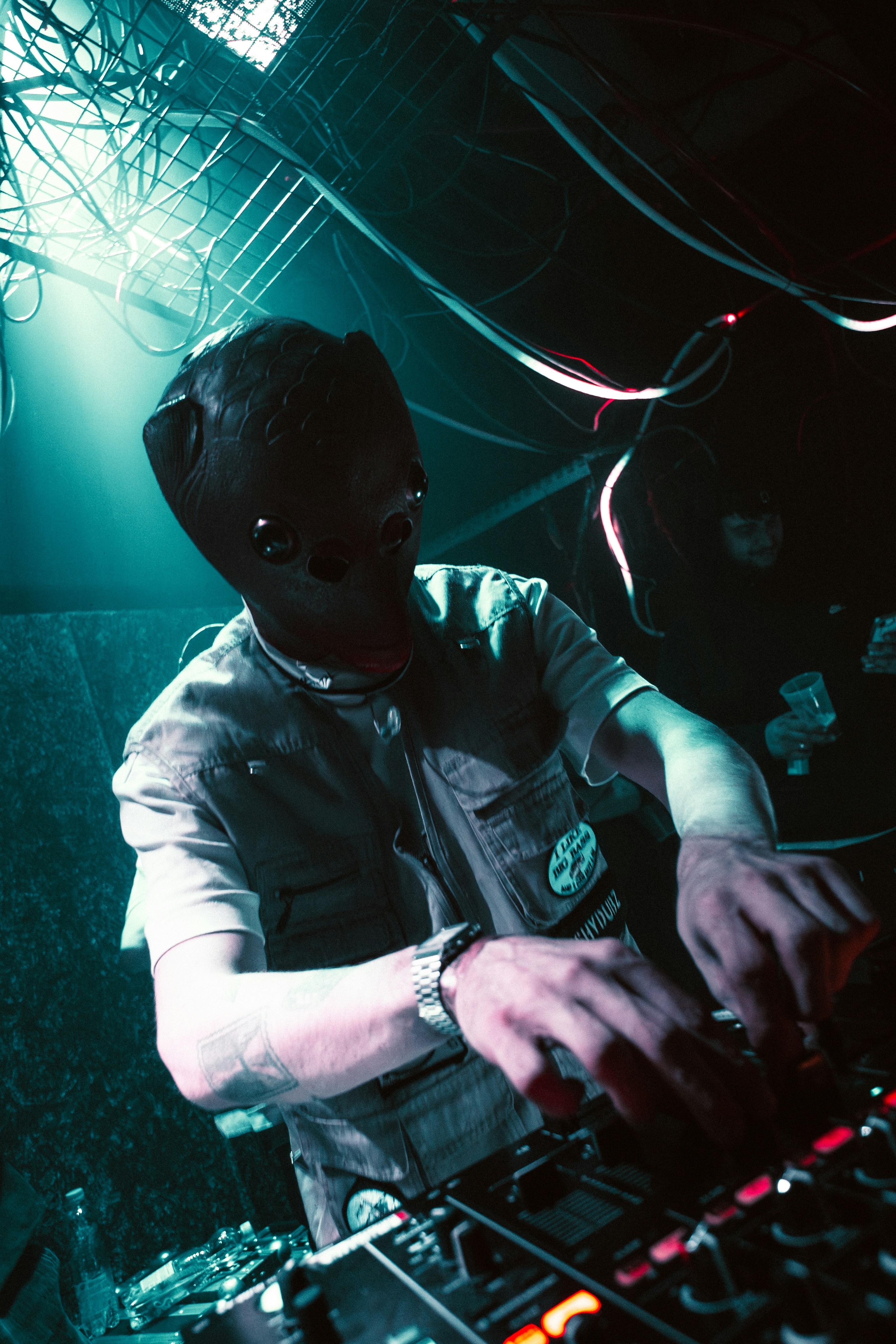 Dj in a dark mask mixing music in a club