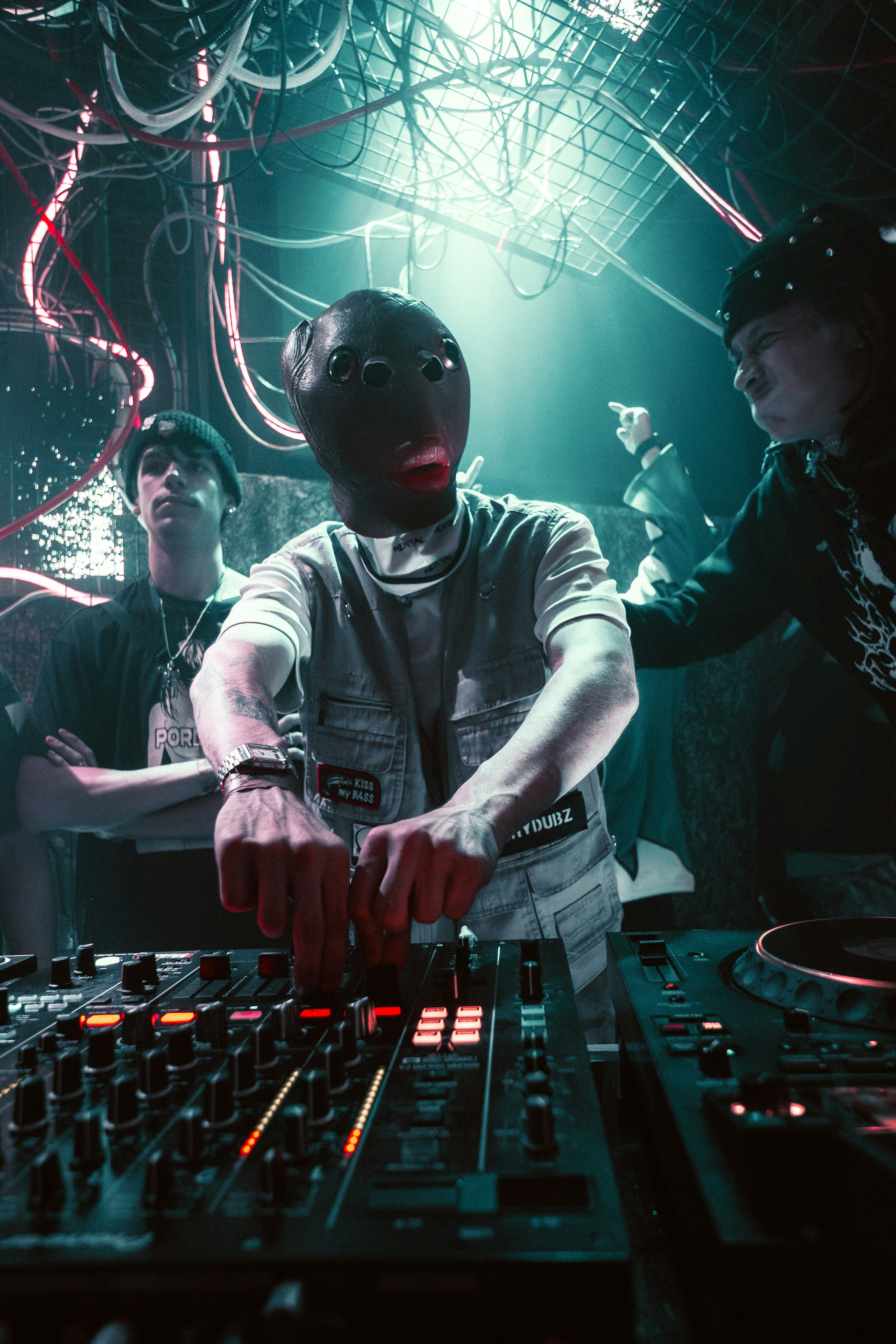 A masked dj mixing music at a vibrant club party