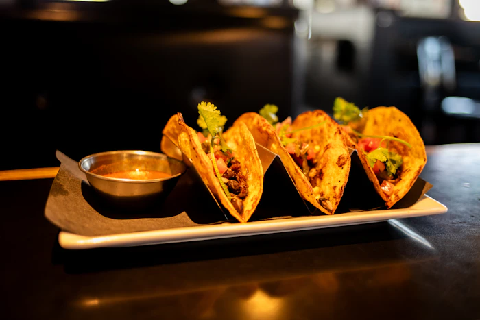 Tacos plated with salsa on the side