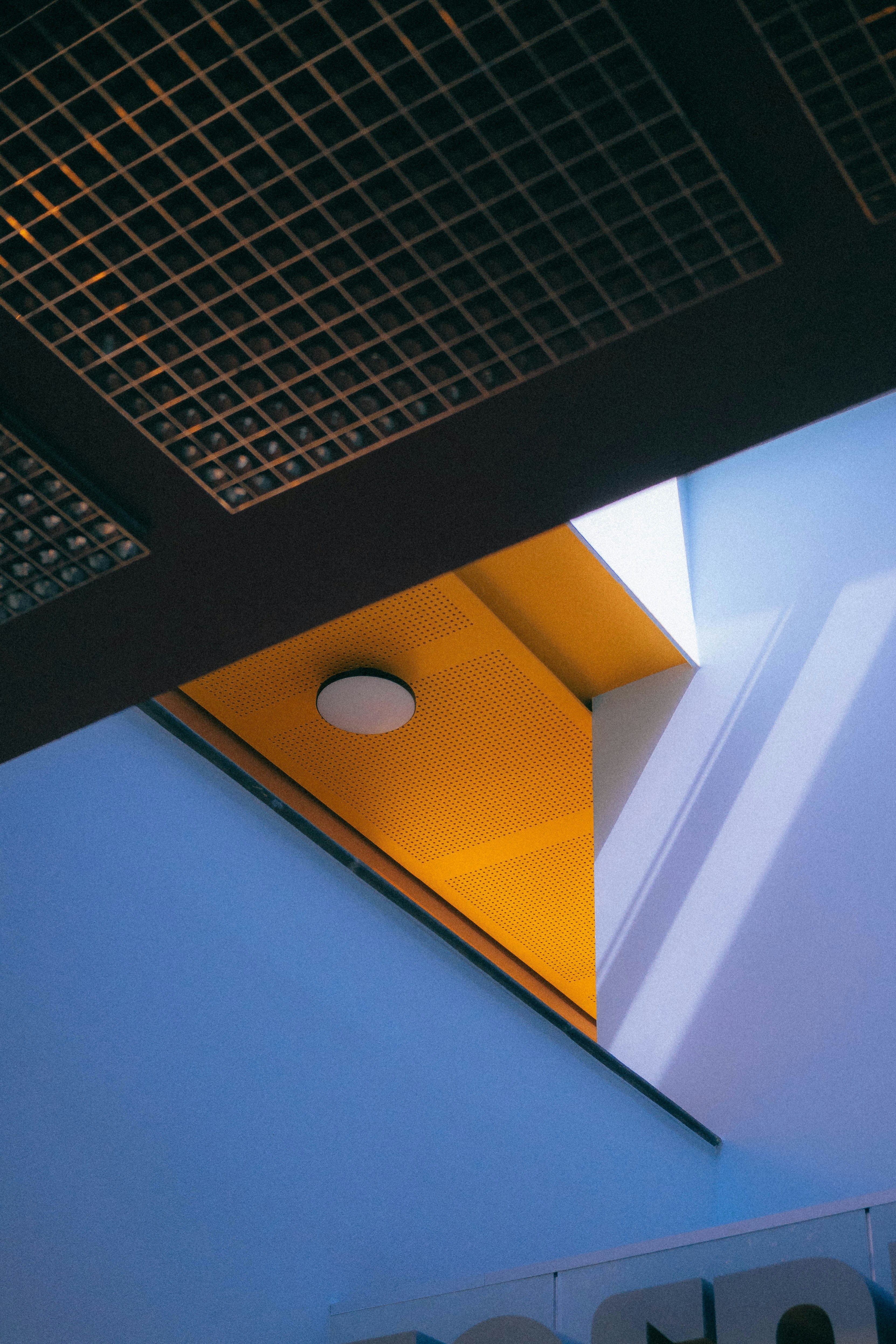 Contrasting blue and yellow architectural elements with grid ceiling.