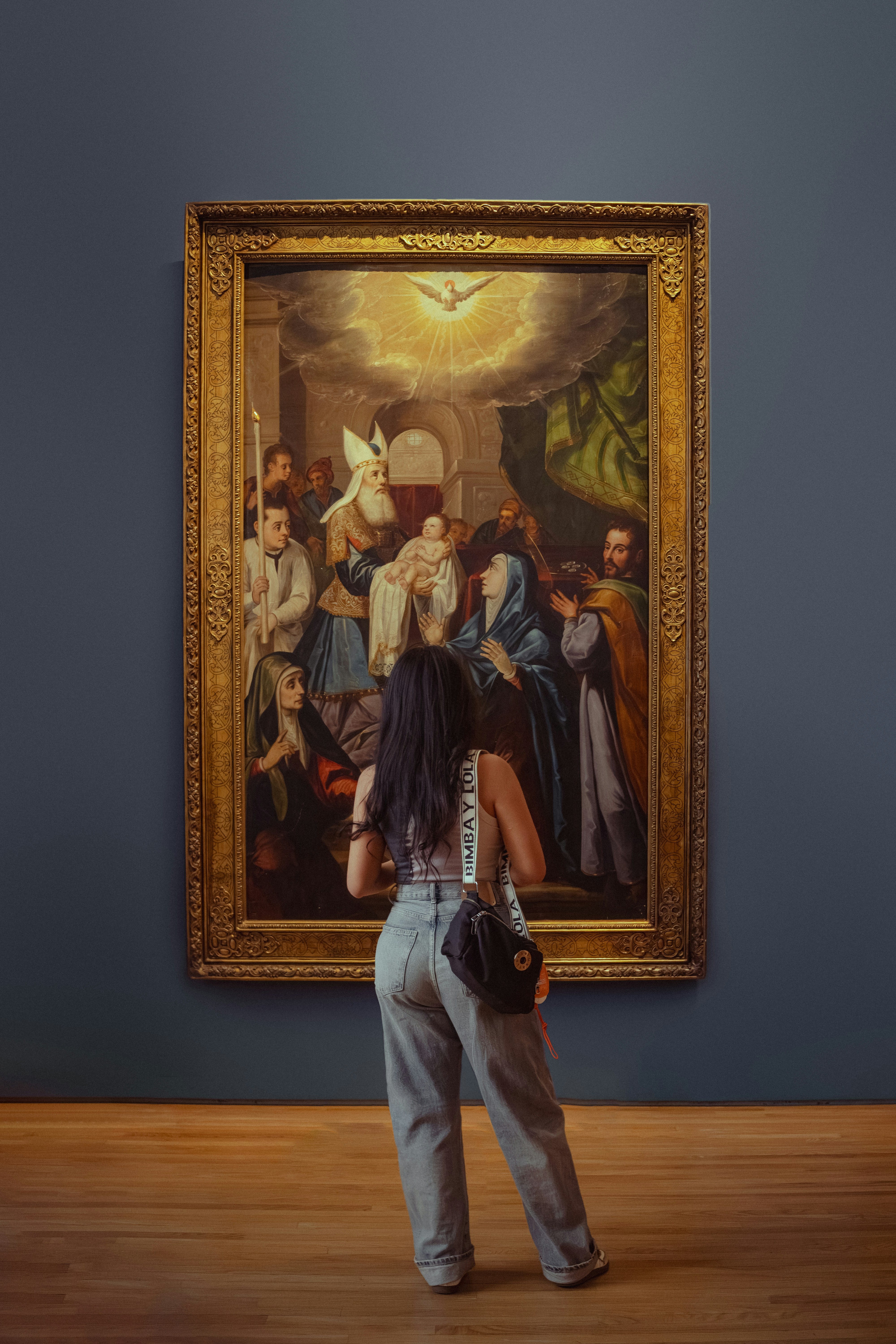 Woman viewing a religious painting in an art gallery.