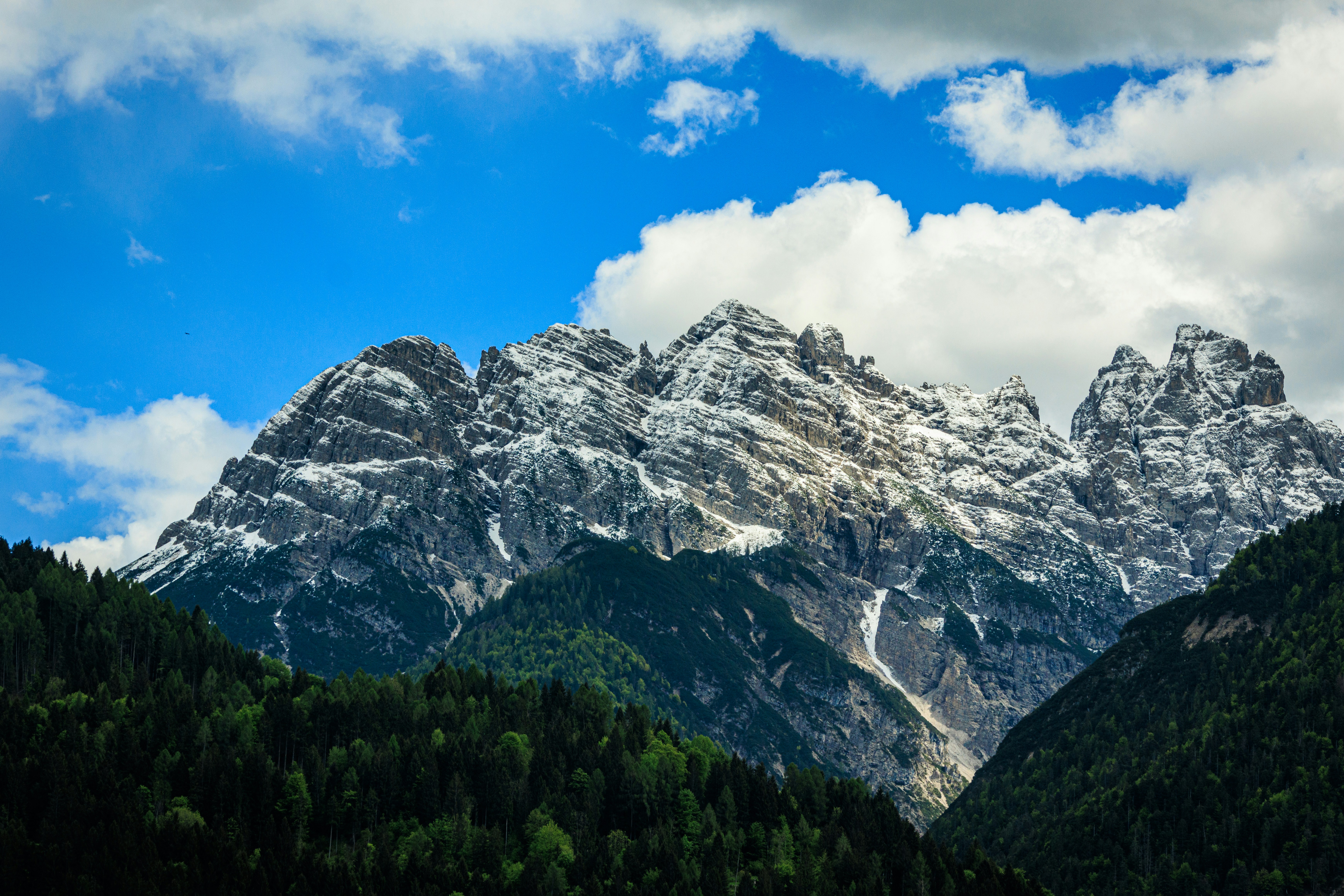 Mountains Towering Snow Capped Mountains Above A Lush Green Forest. 4K Wallpaper #3564