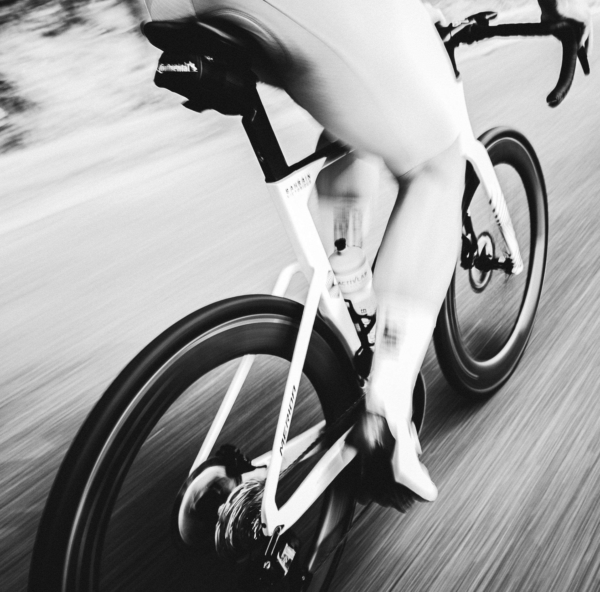 Cyclist speeding on a road, captured with motion blur.