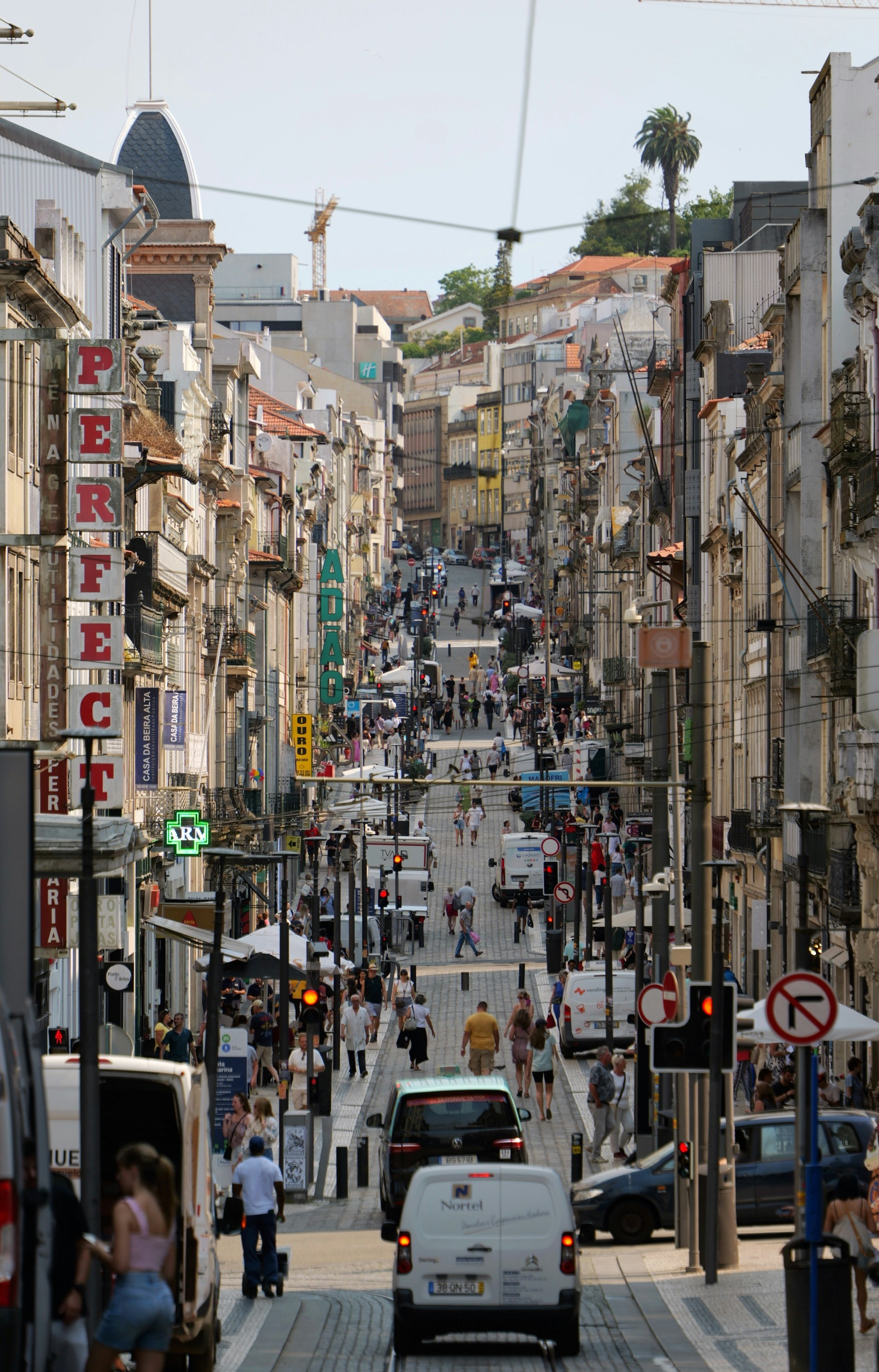 A bustling european street filled with pedestrians and traffic.