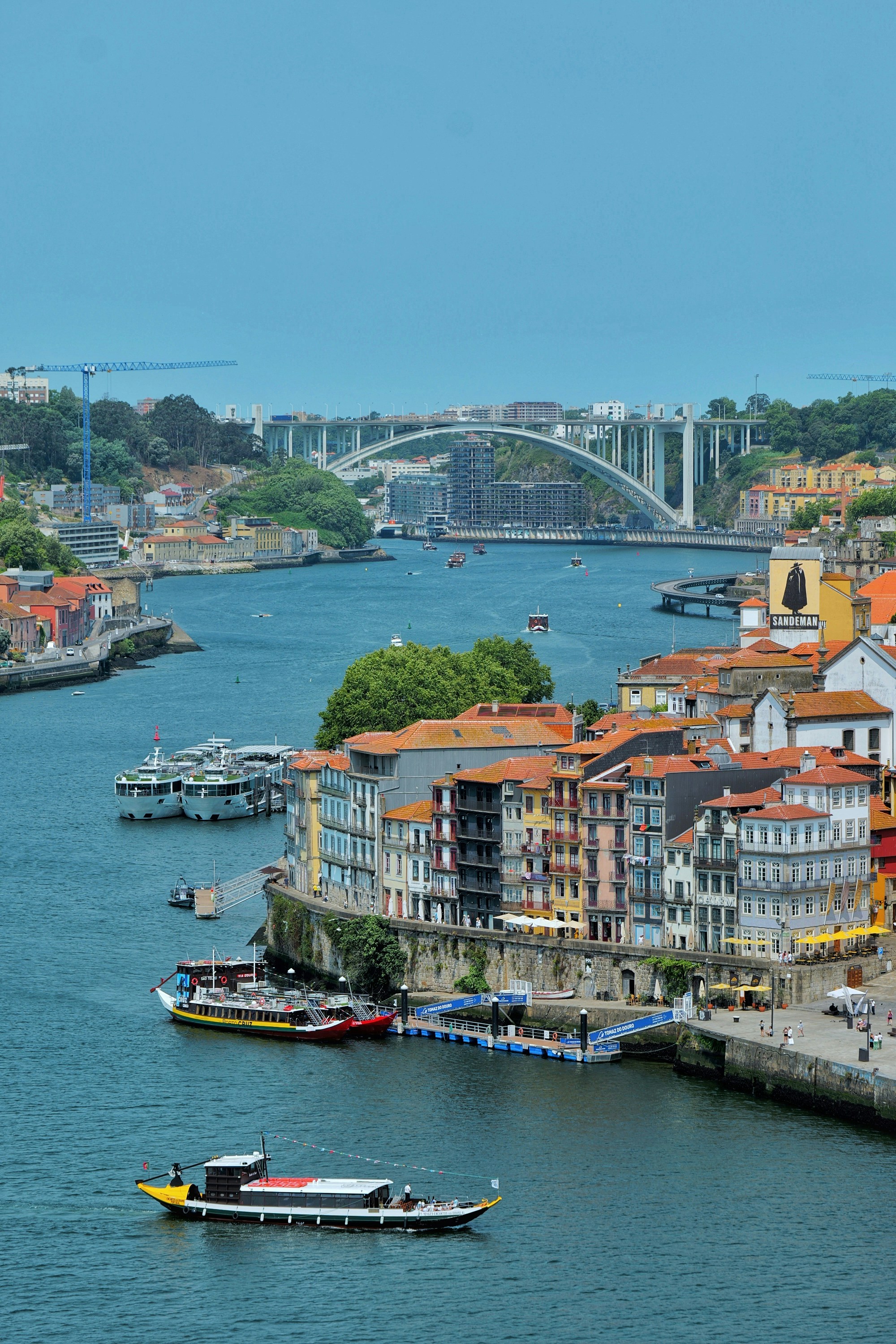 Porto cityscape with douro river, historic buildings, and boats.