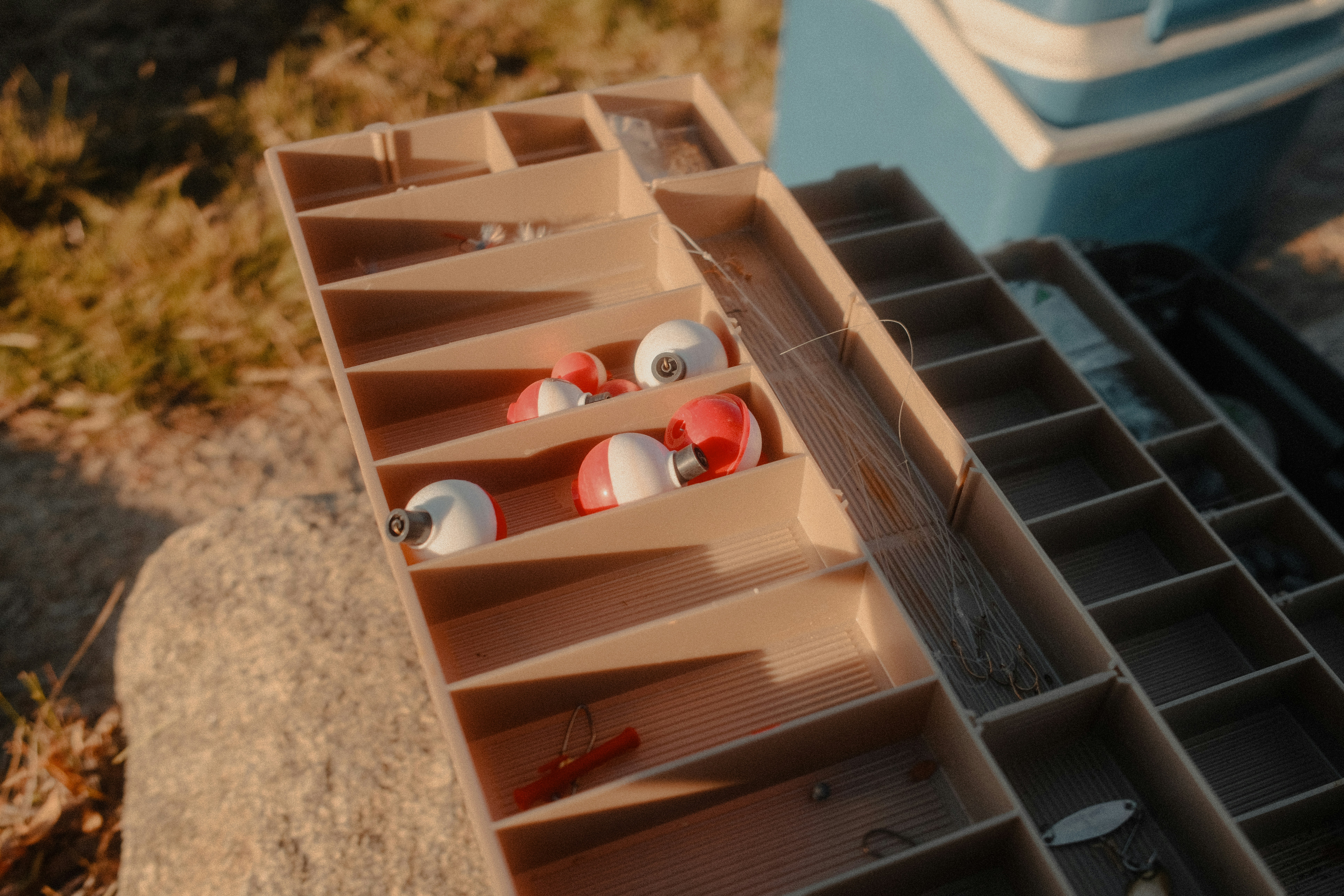 Fishing tackle box with red and white bobbers