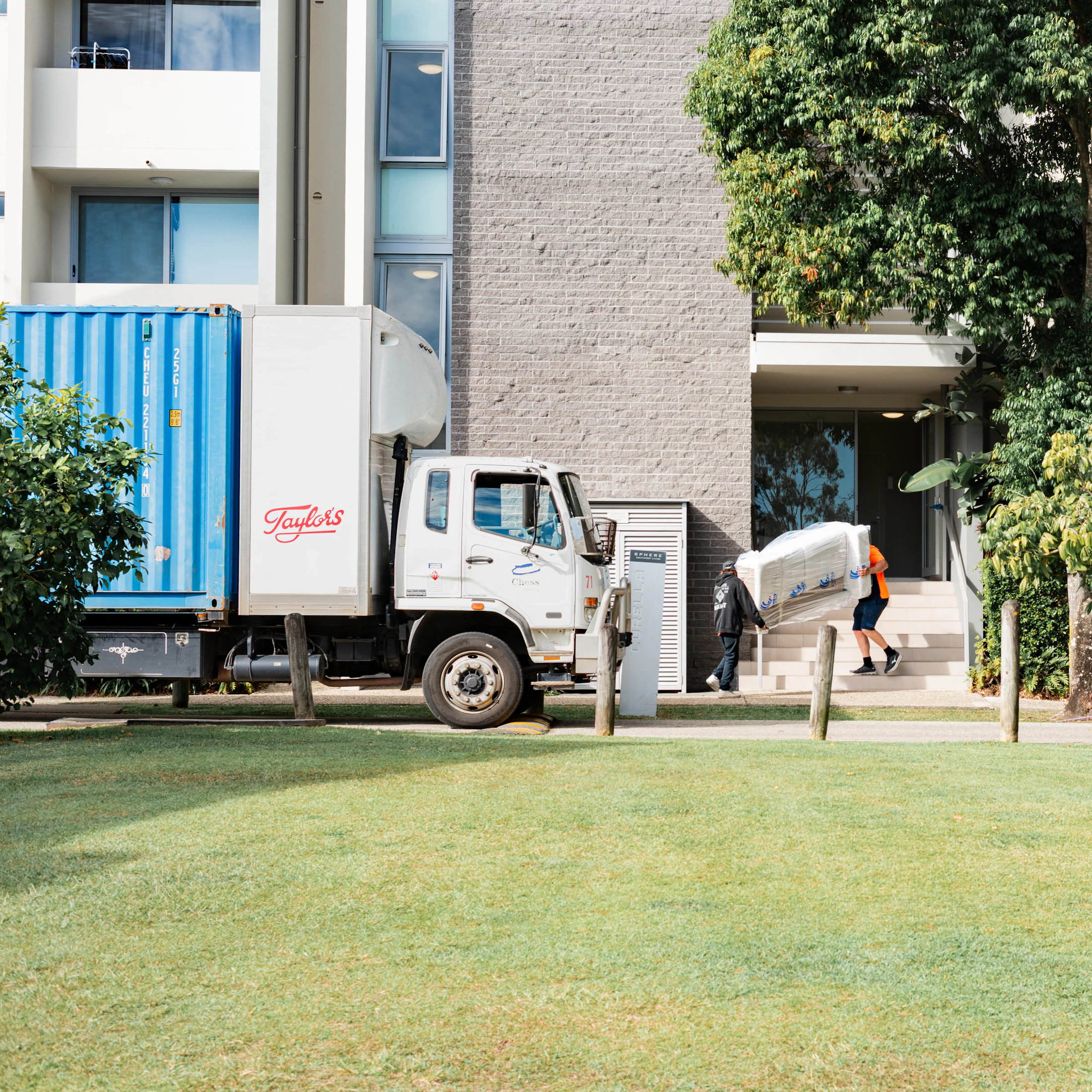 Moving truck parked while a mover carries furniture into a building