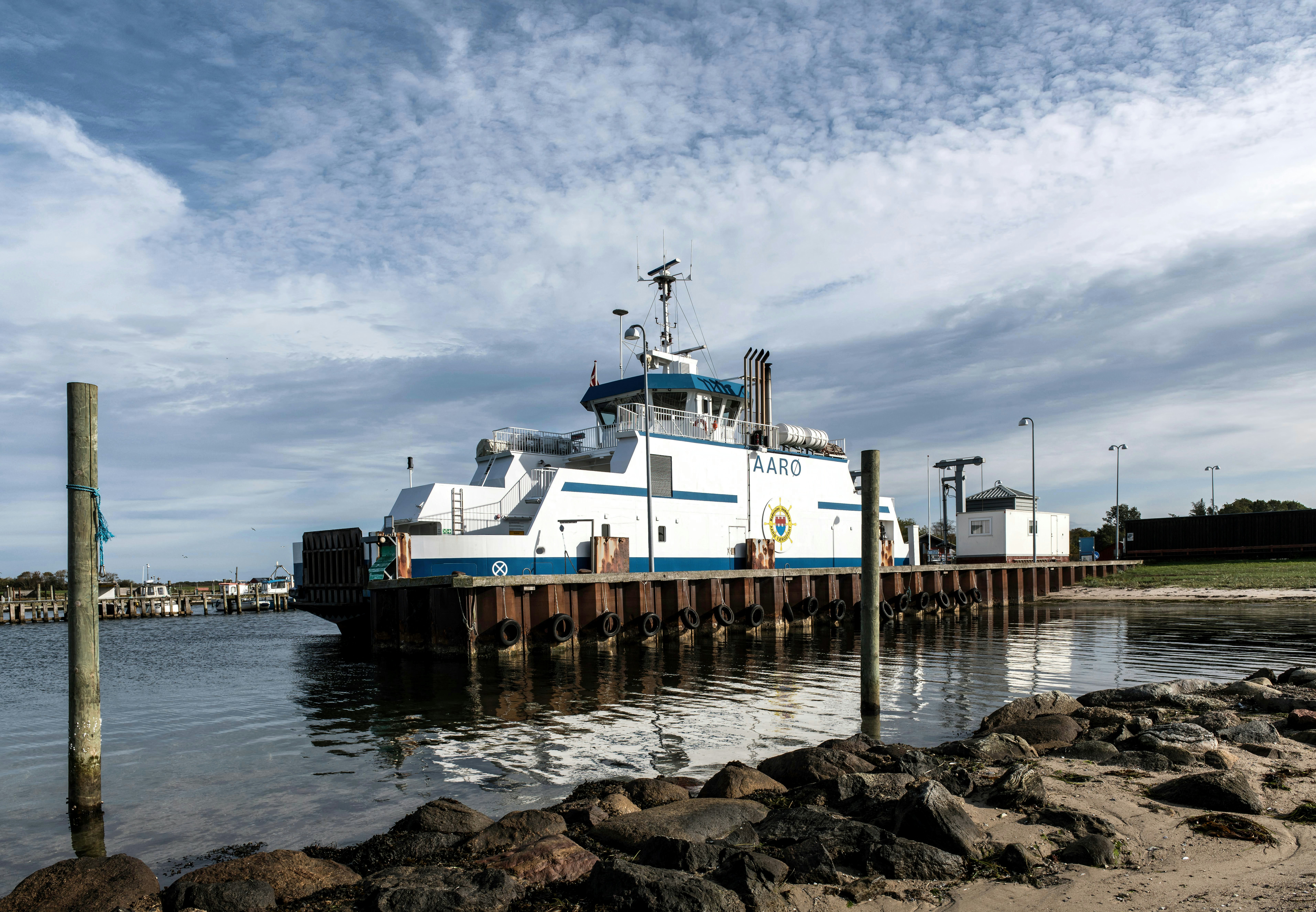 Ferry boat docked at a pier on a cloudy day.